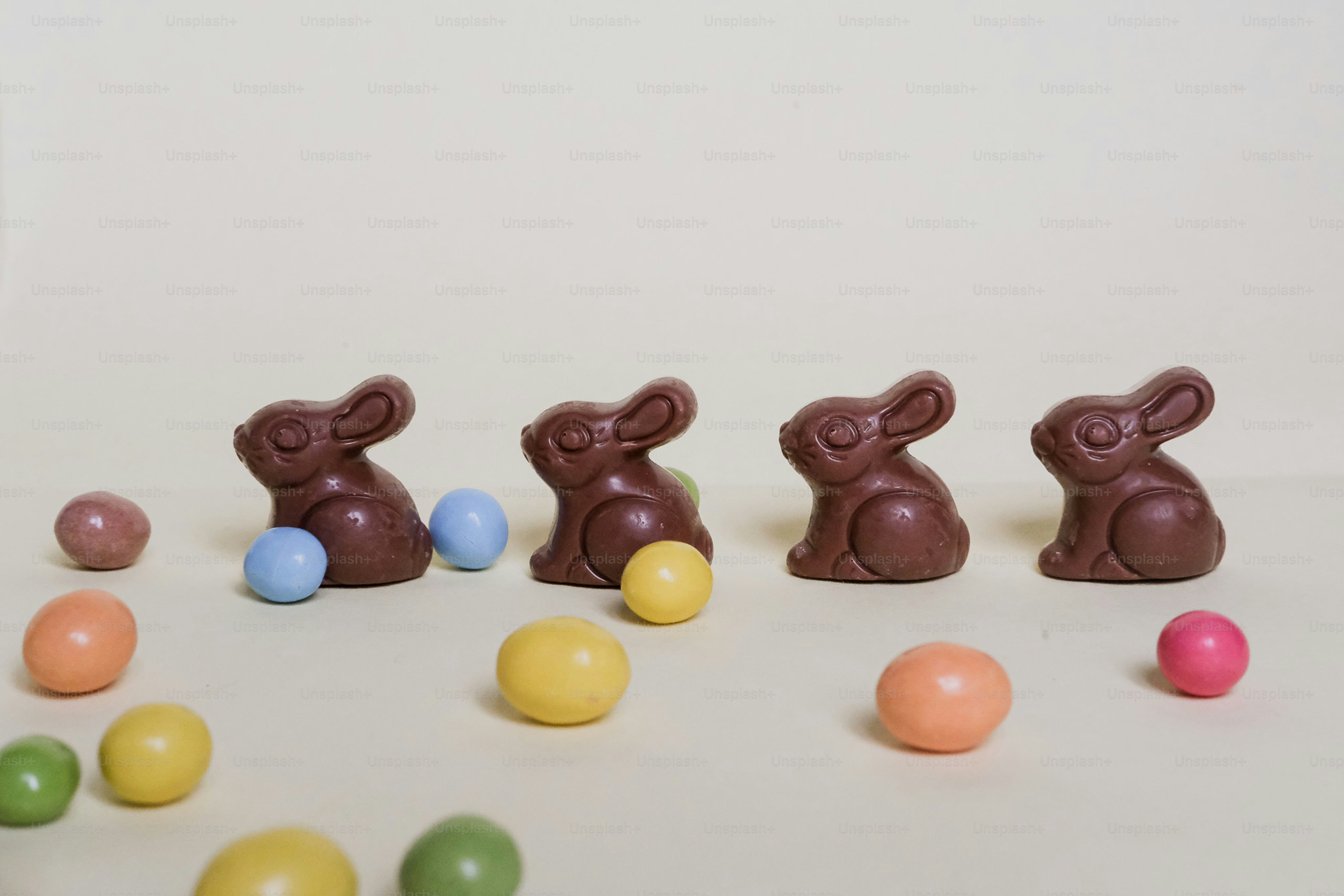 Four chocolate bunnies with colorful candy eggs