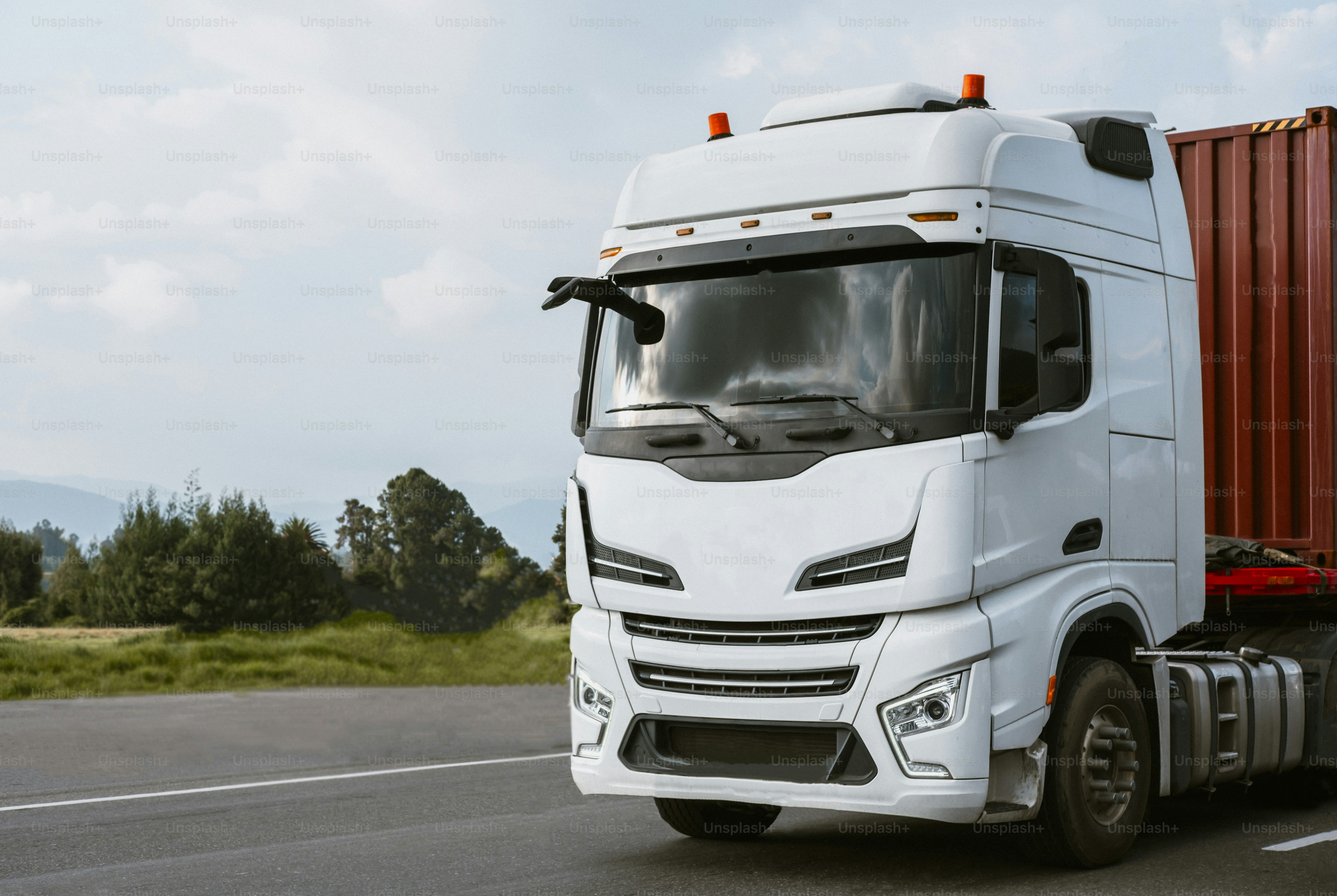 도로를 달리는 흰색 대형 트럭.