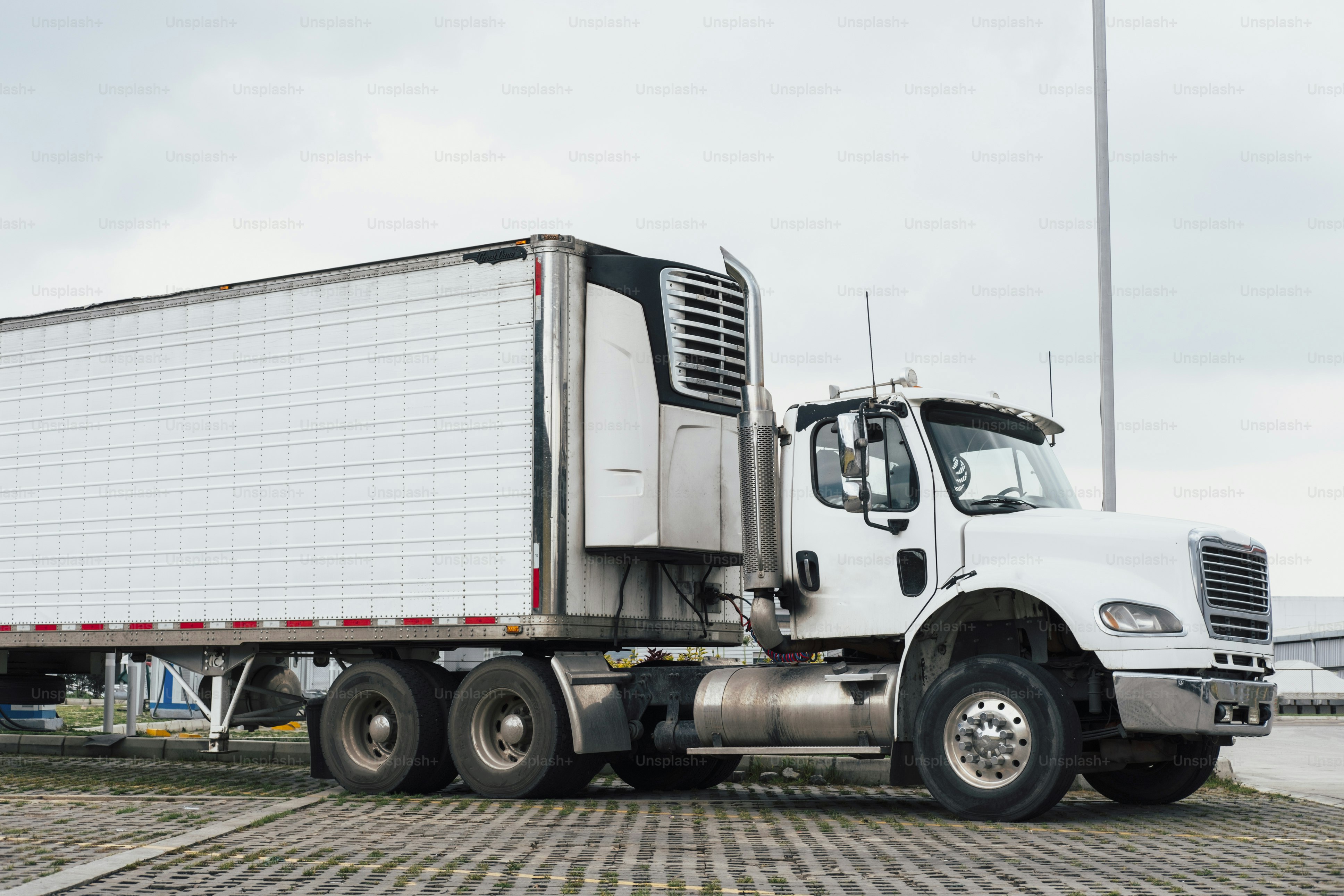 하얀 세미 트럭에 냉장 트레일러가 주차되어 있었다.