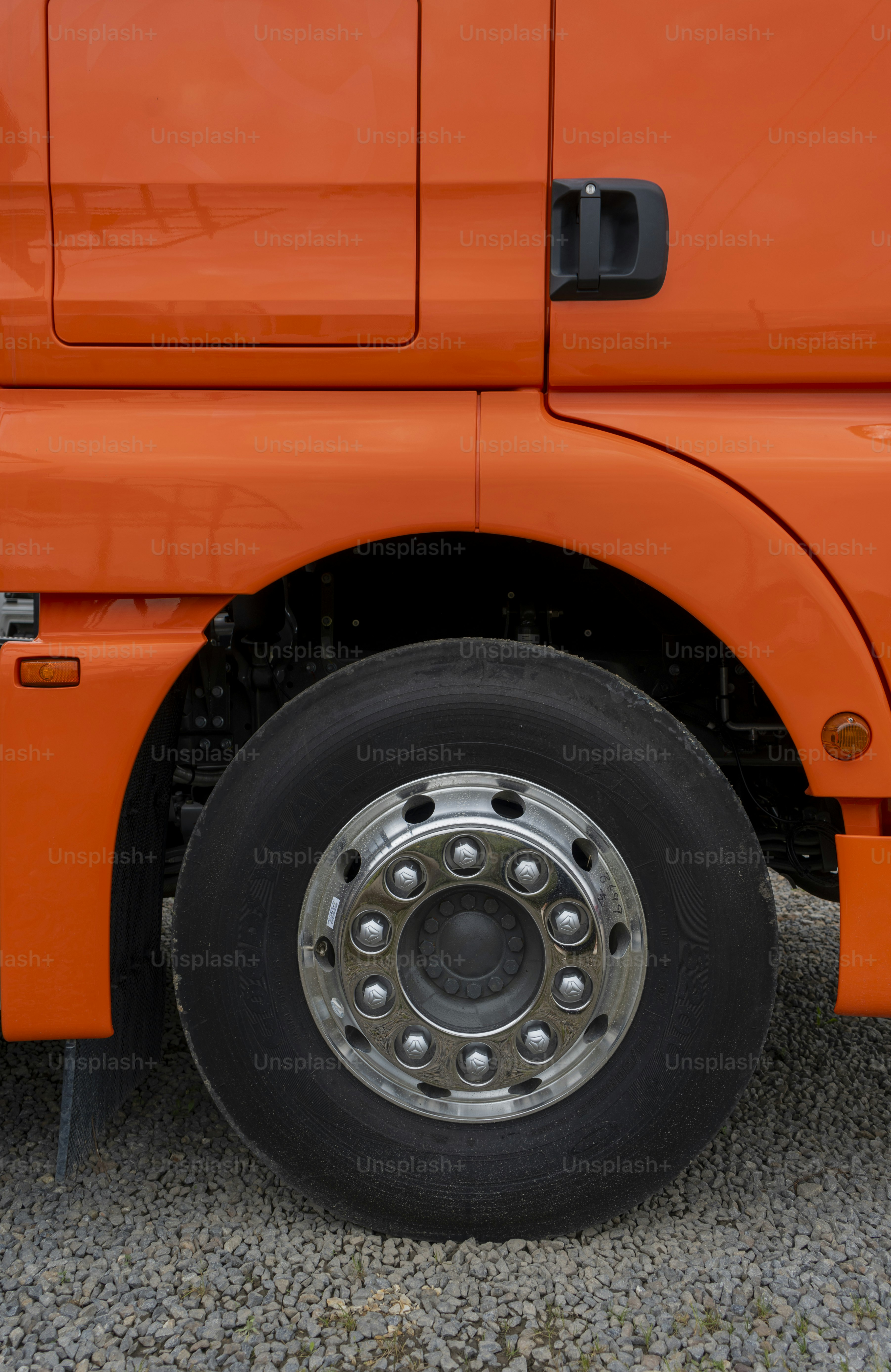 주황색 트럭의 바퀴와 차체 클로즈업