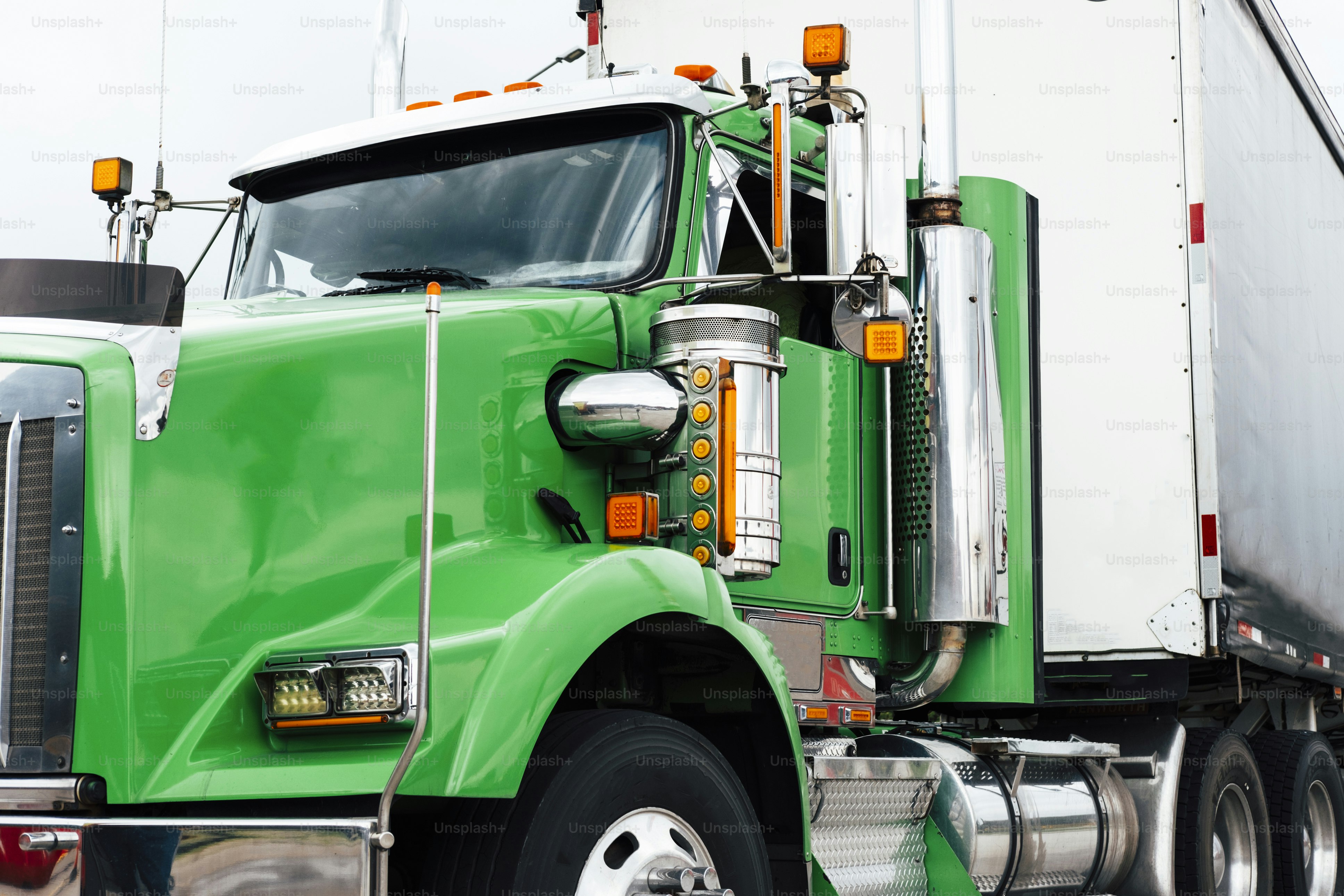 A bright green semi-truck with a white trailer.