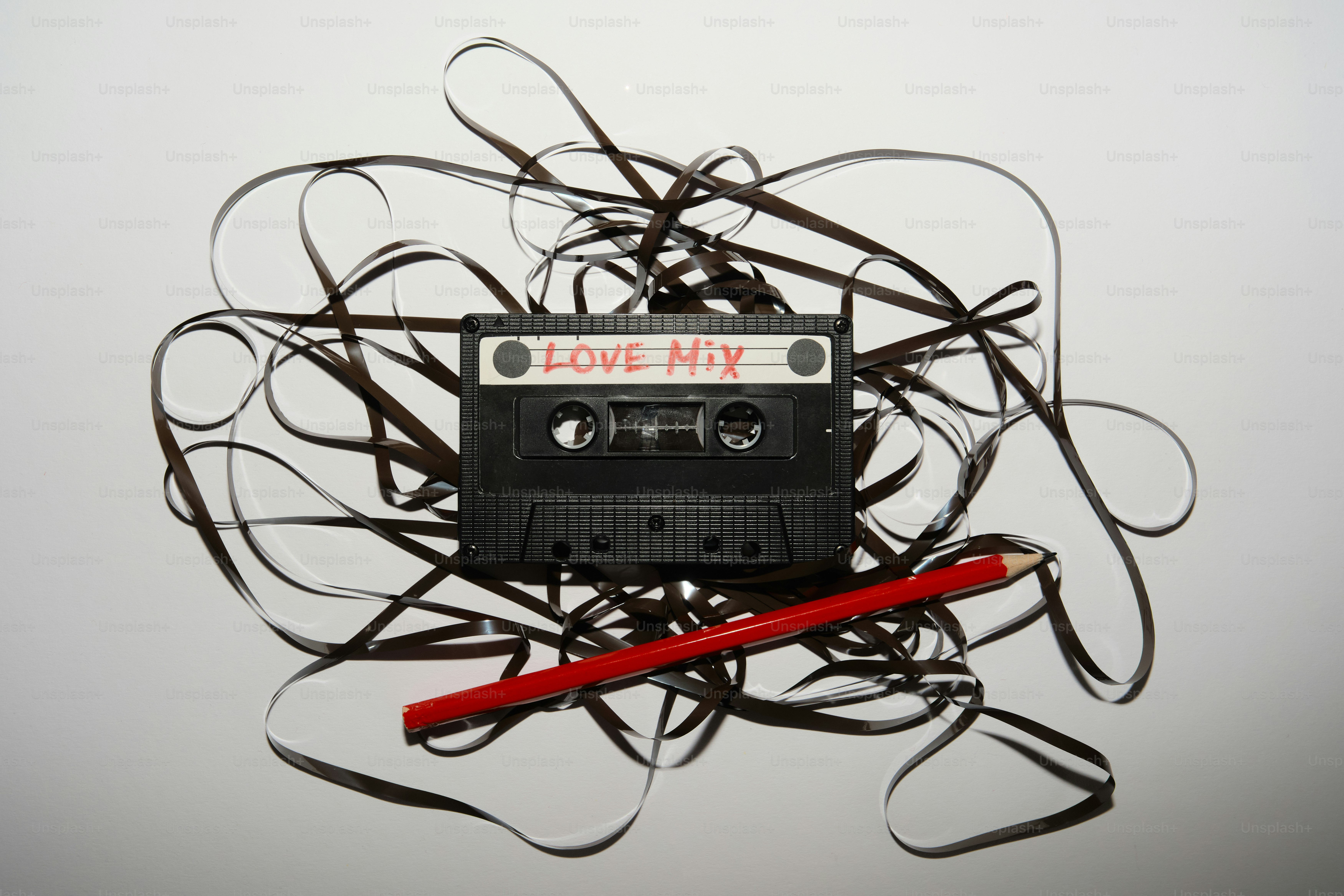 Nastro a cassetta aggrovigliata con una matita rossa e un'etichetta