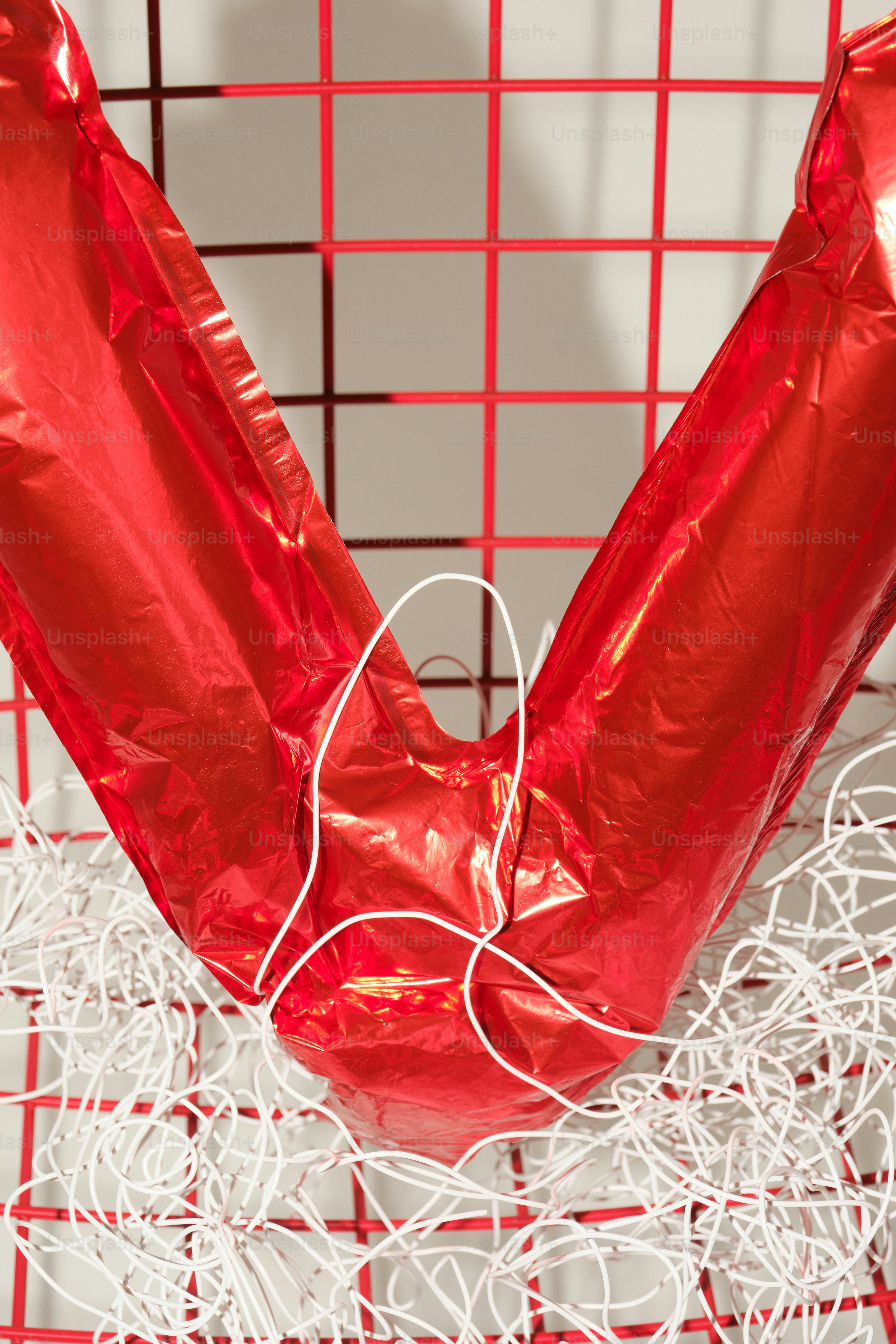 Palloncino a cuore rosso impigliato in una rete bianca