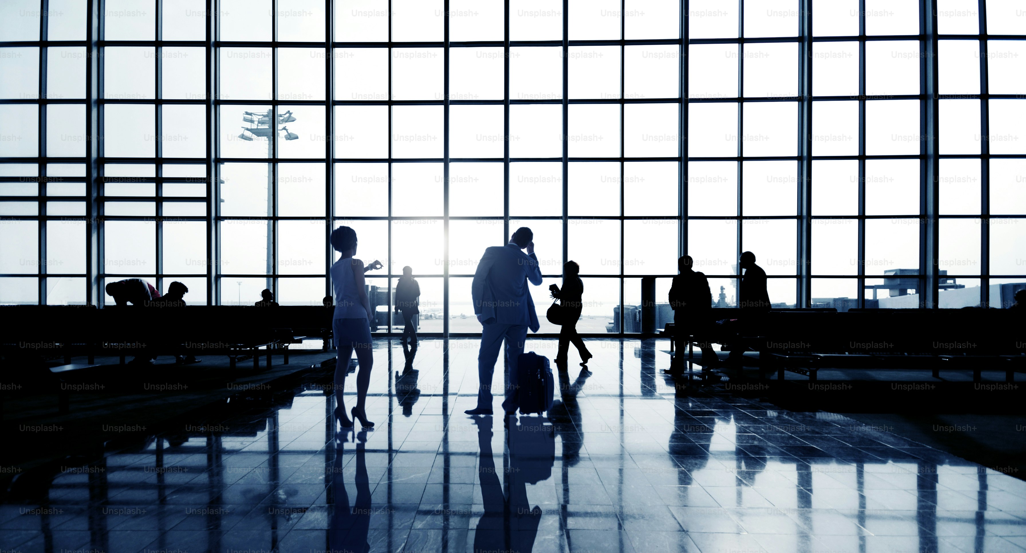 Silhouettes Of Multi-Ethnic Group Of Business People Waiting In An Airport Terminal