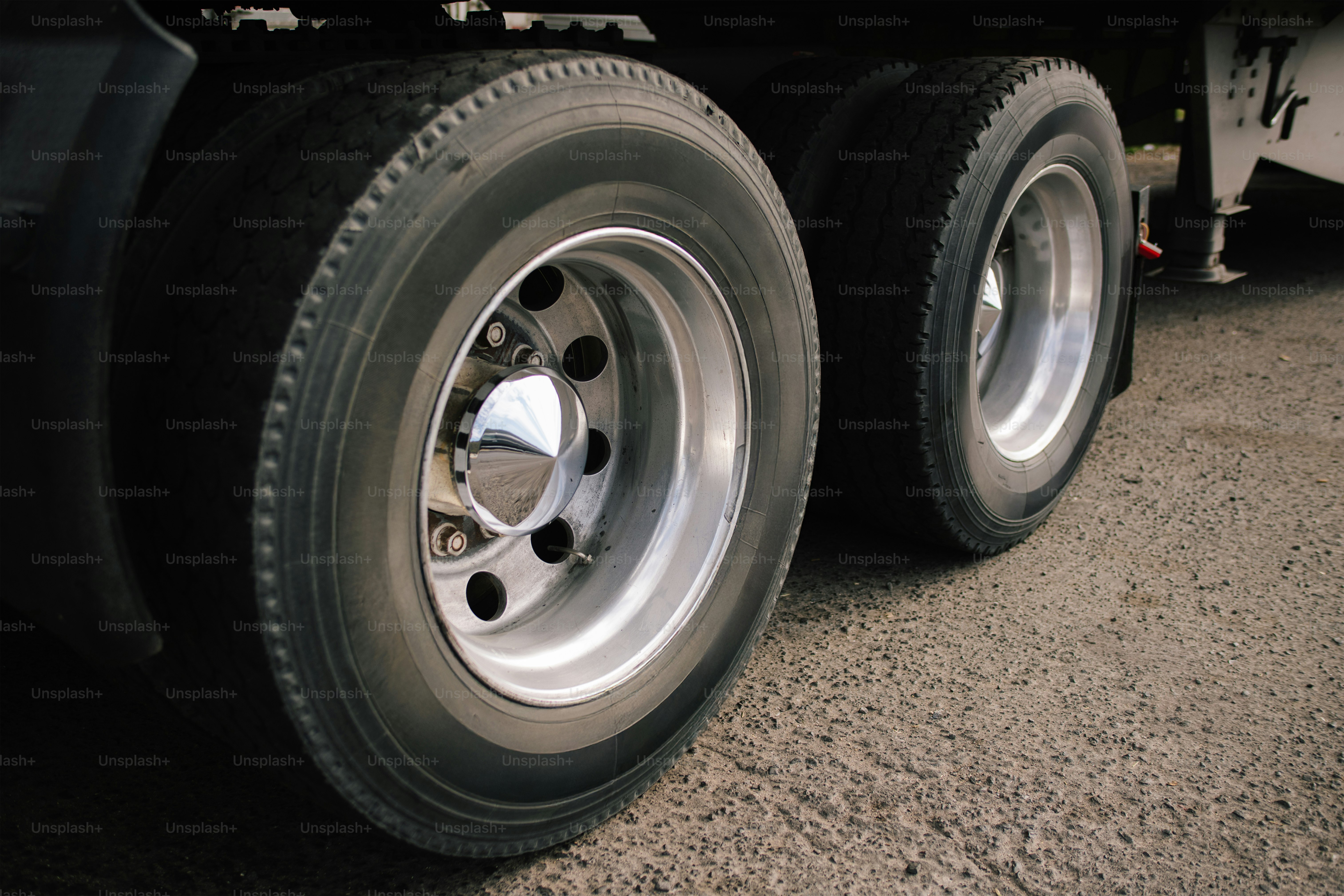 Close-up of dual truck tires on a gravel surface