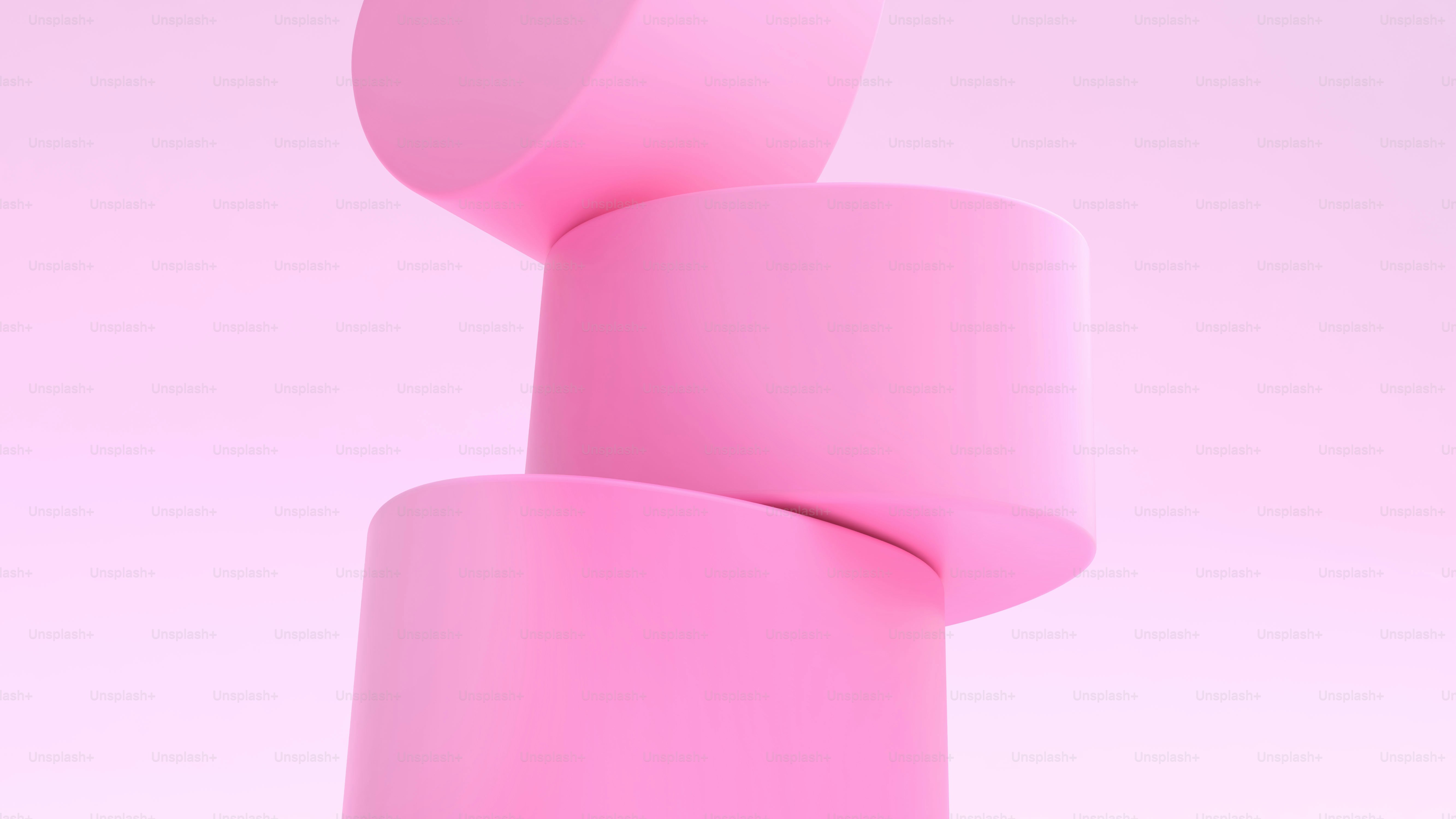 Three pink cylinders stacked on a pink background
