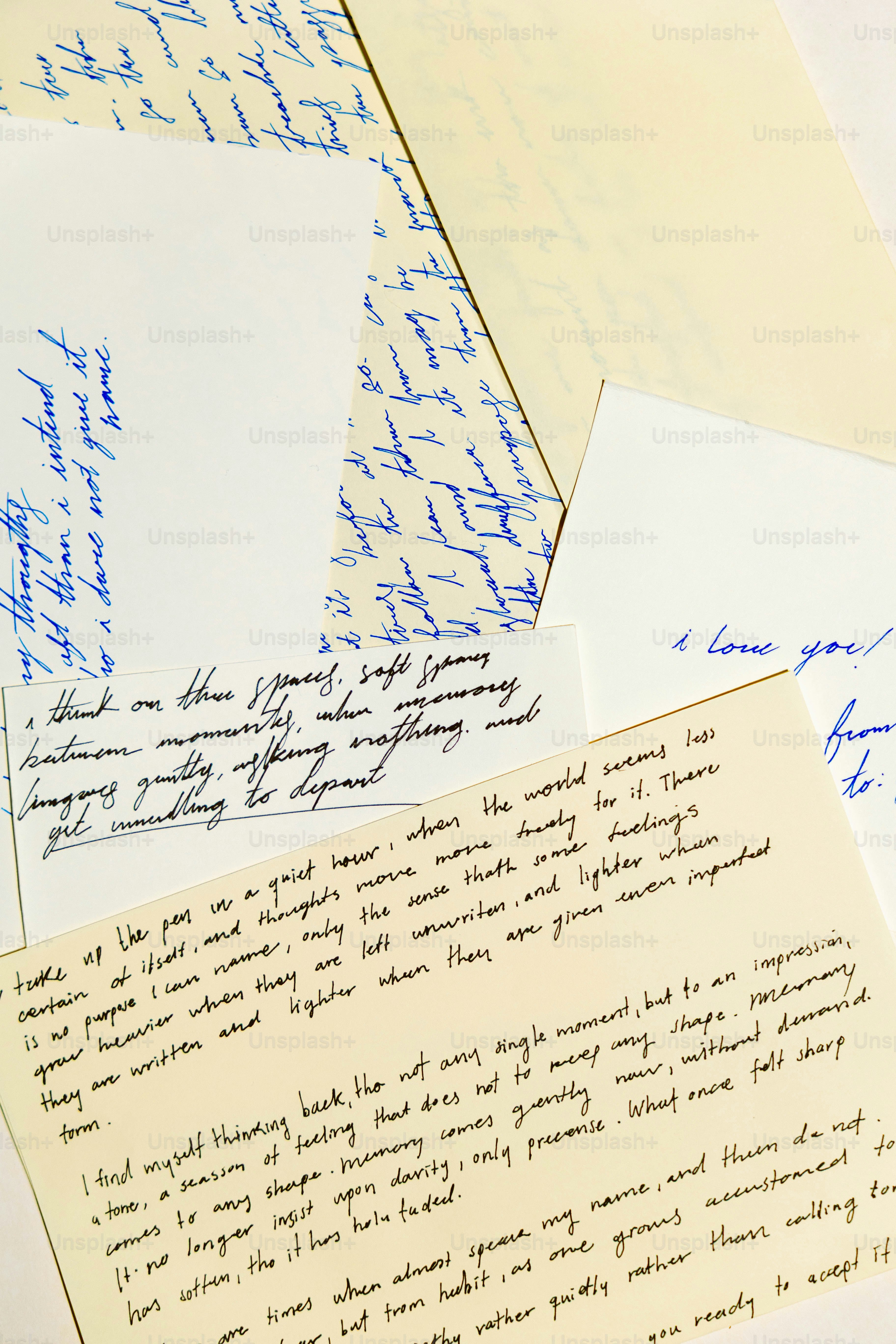 Scattered handwritten letters with blue ink on paper.