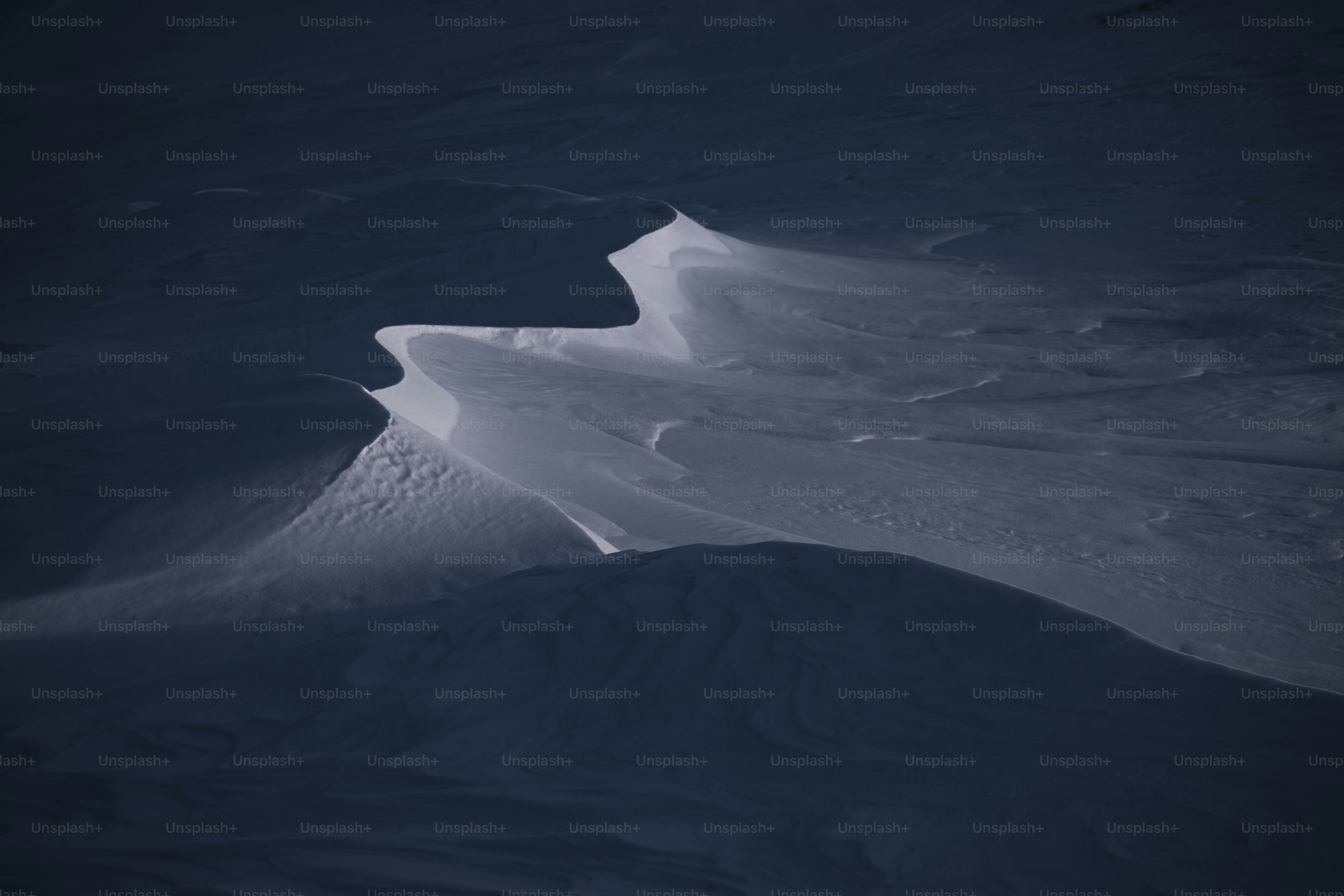 Abstract pattern of snow drifts under moonlight