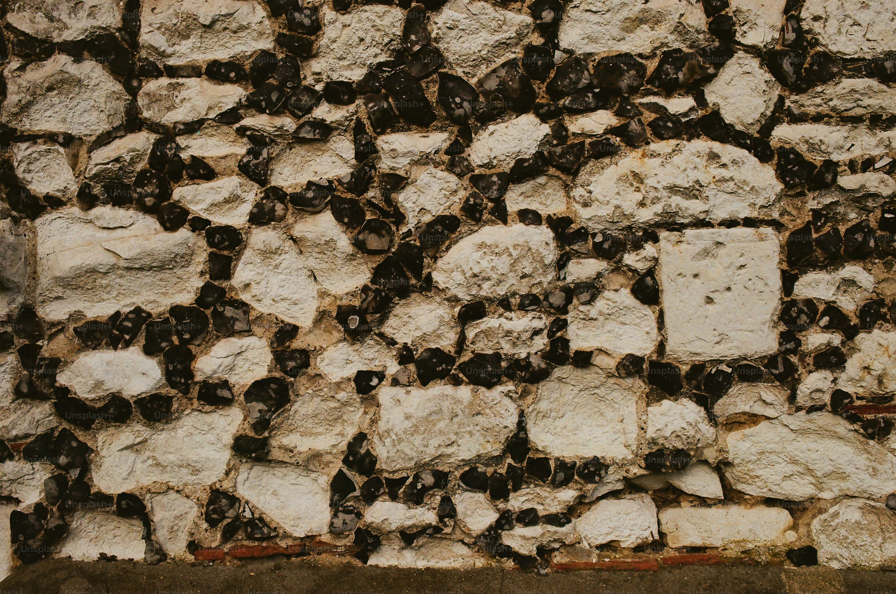 A textured wall made of rough stones and mortar.