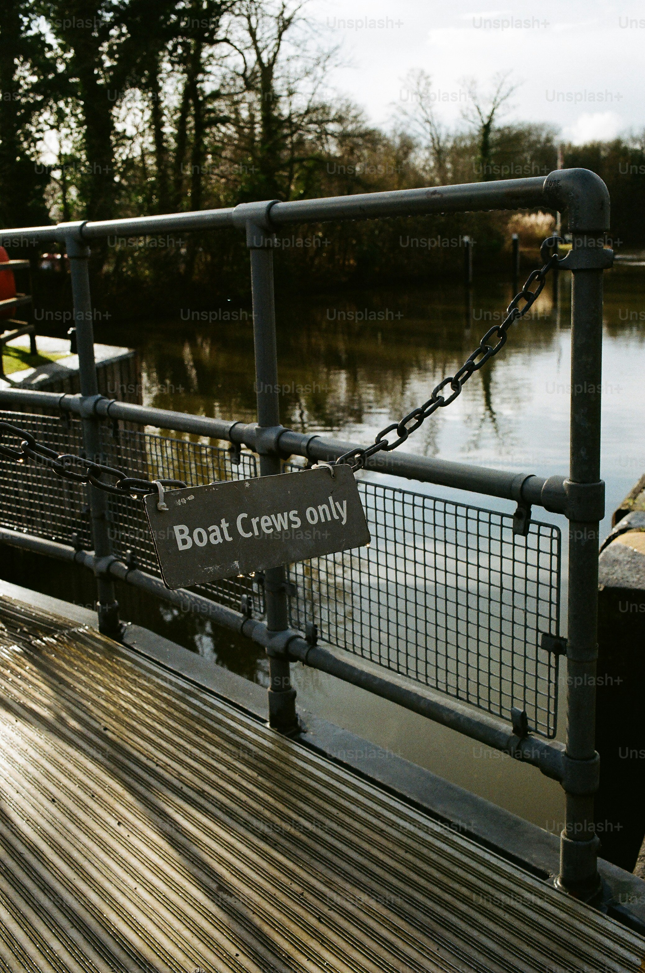 Sign on a metal railing by a body of water