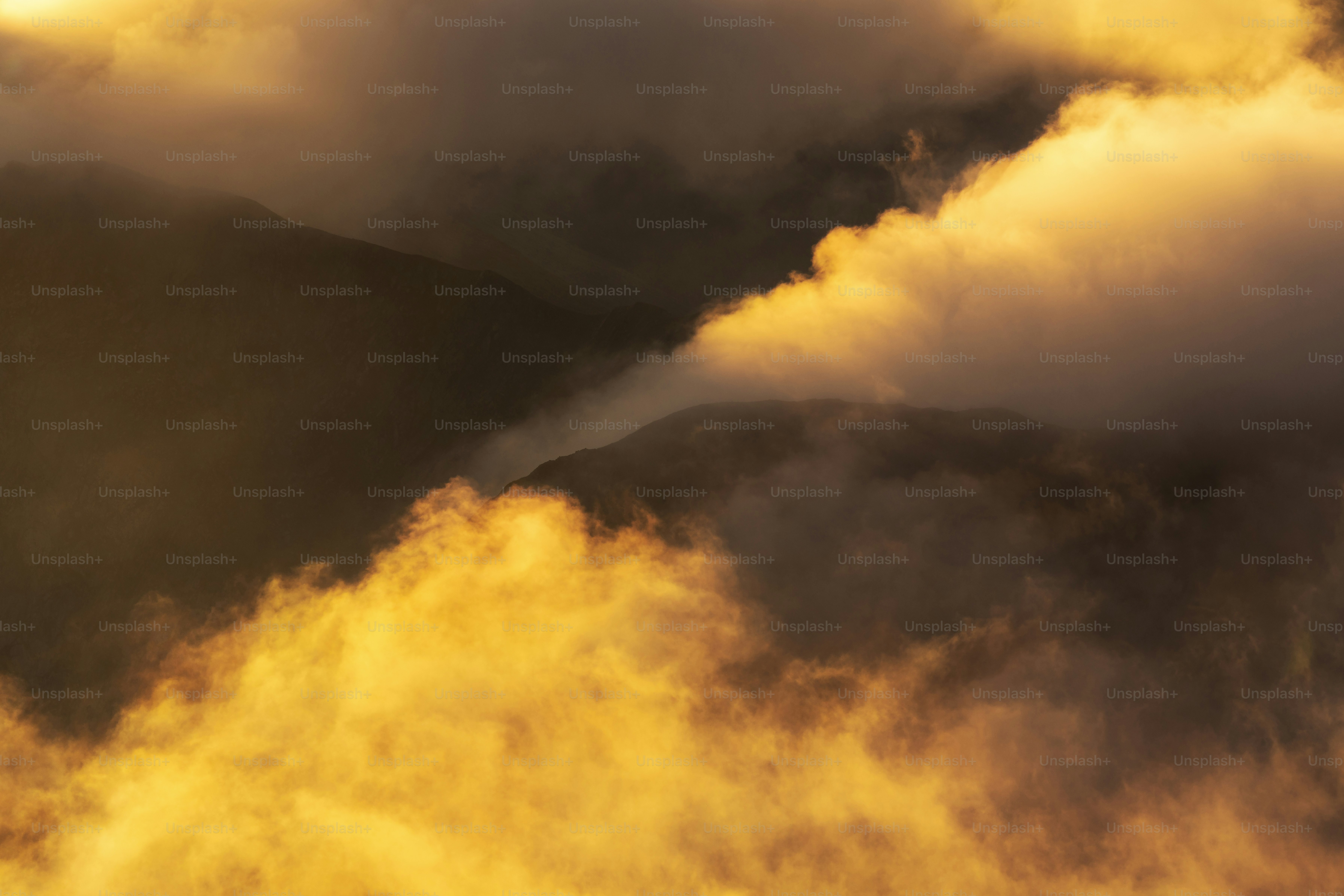 Nuvole dorate oscurano una vetta montana lontana all'alba.