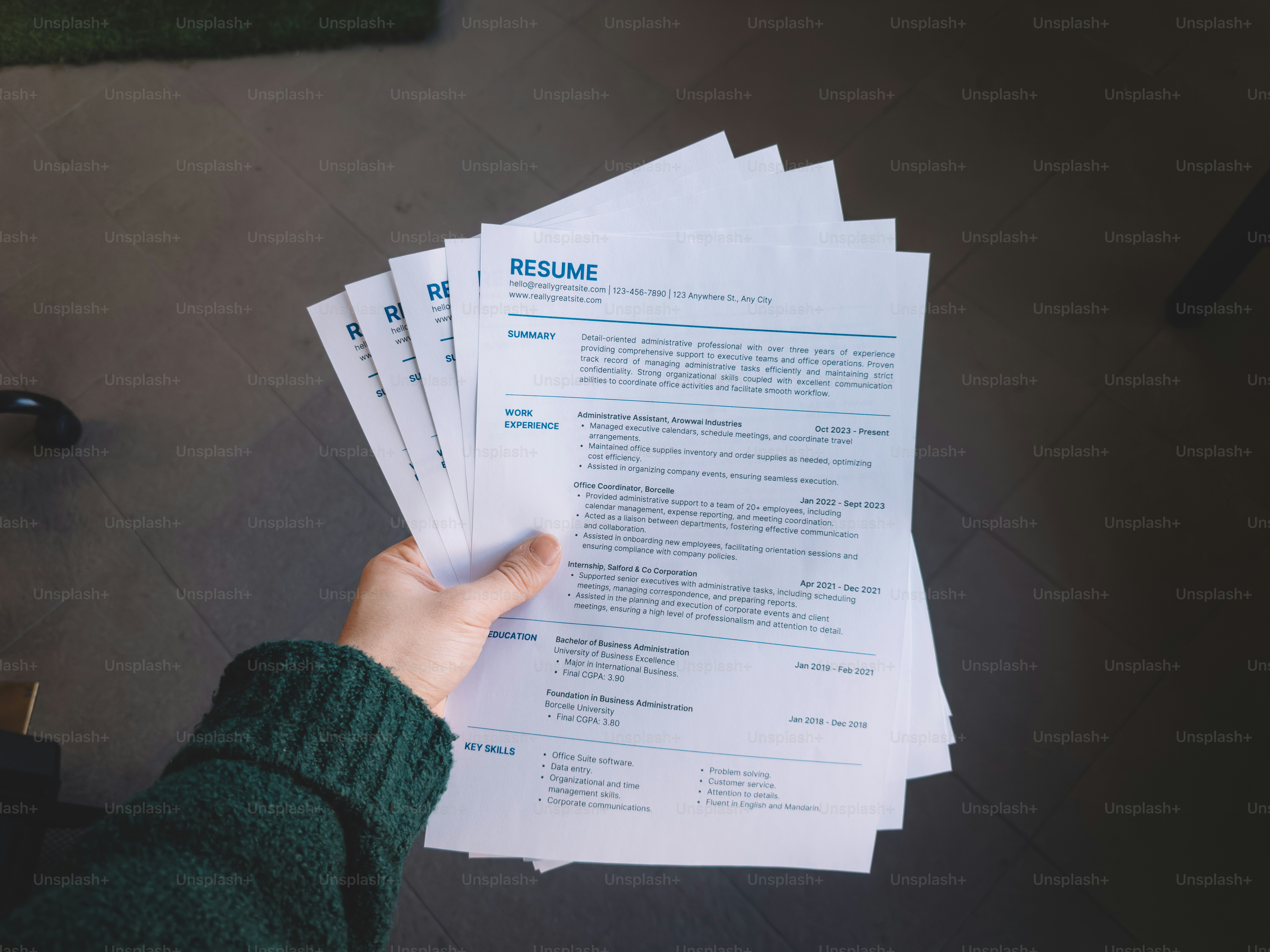 Hand holding a stack of resumes