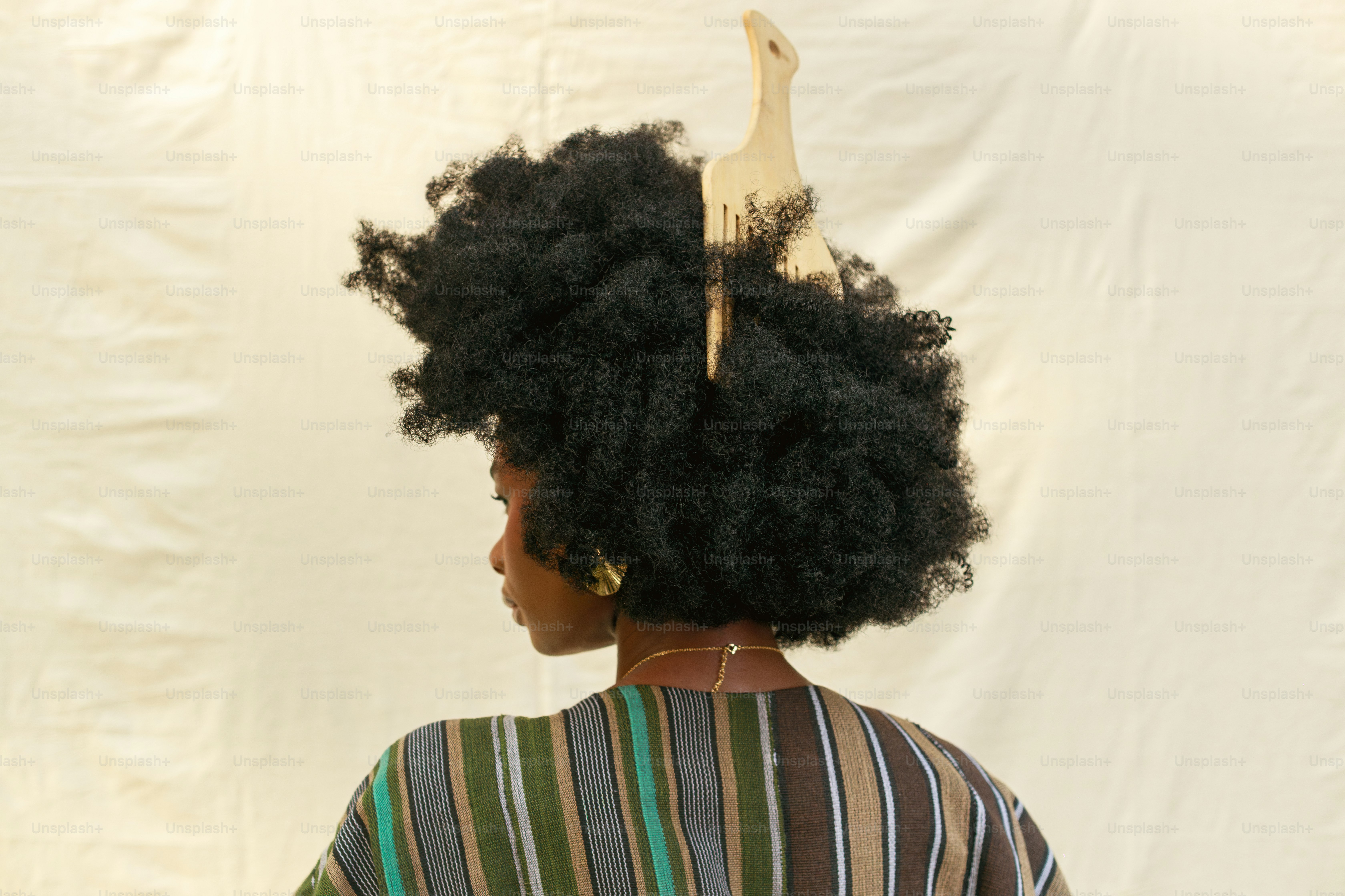 Donna con grande acconciatura afro e accessori a pennello