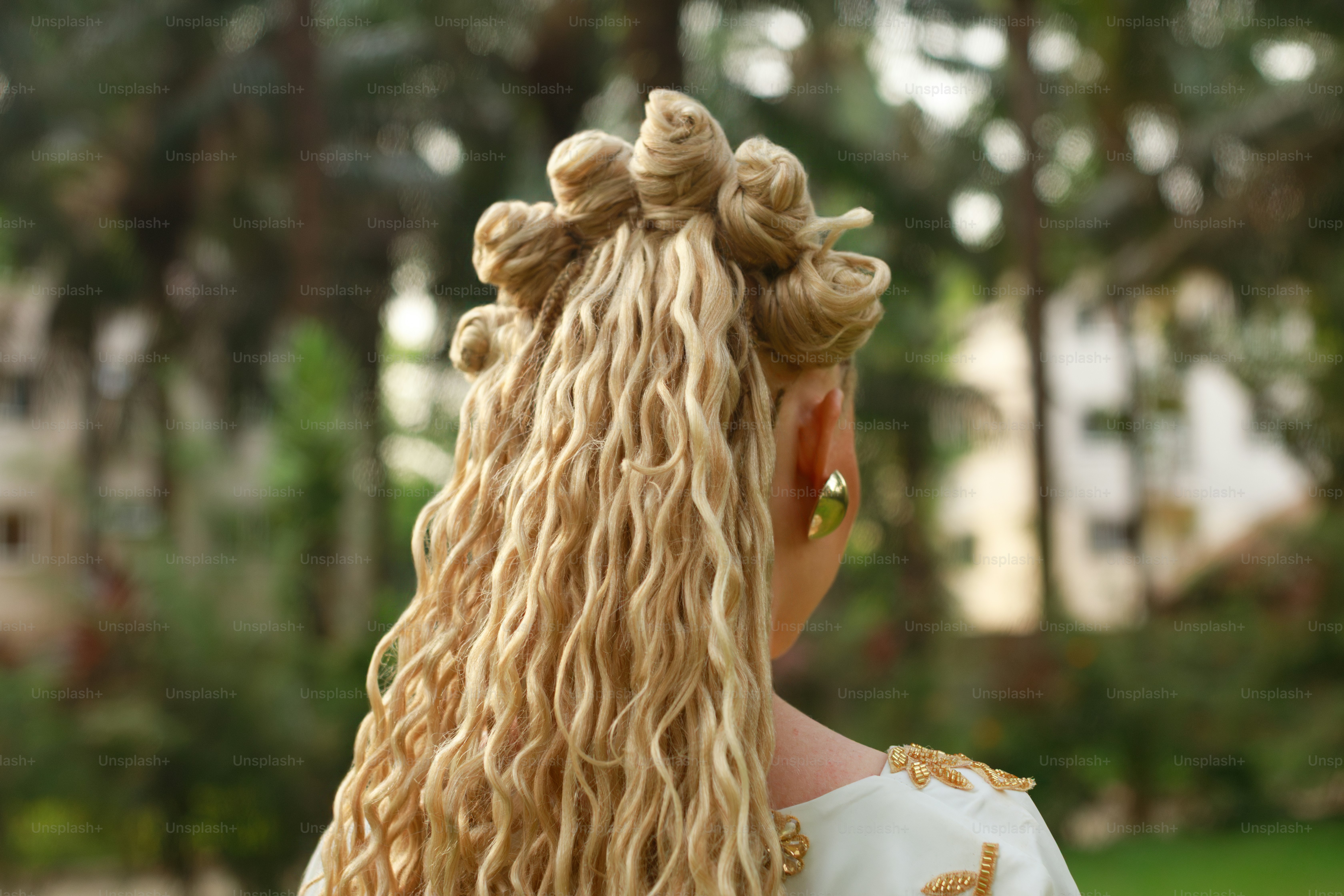Femme avec une coiffure blonde tressée élaborée en plein air