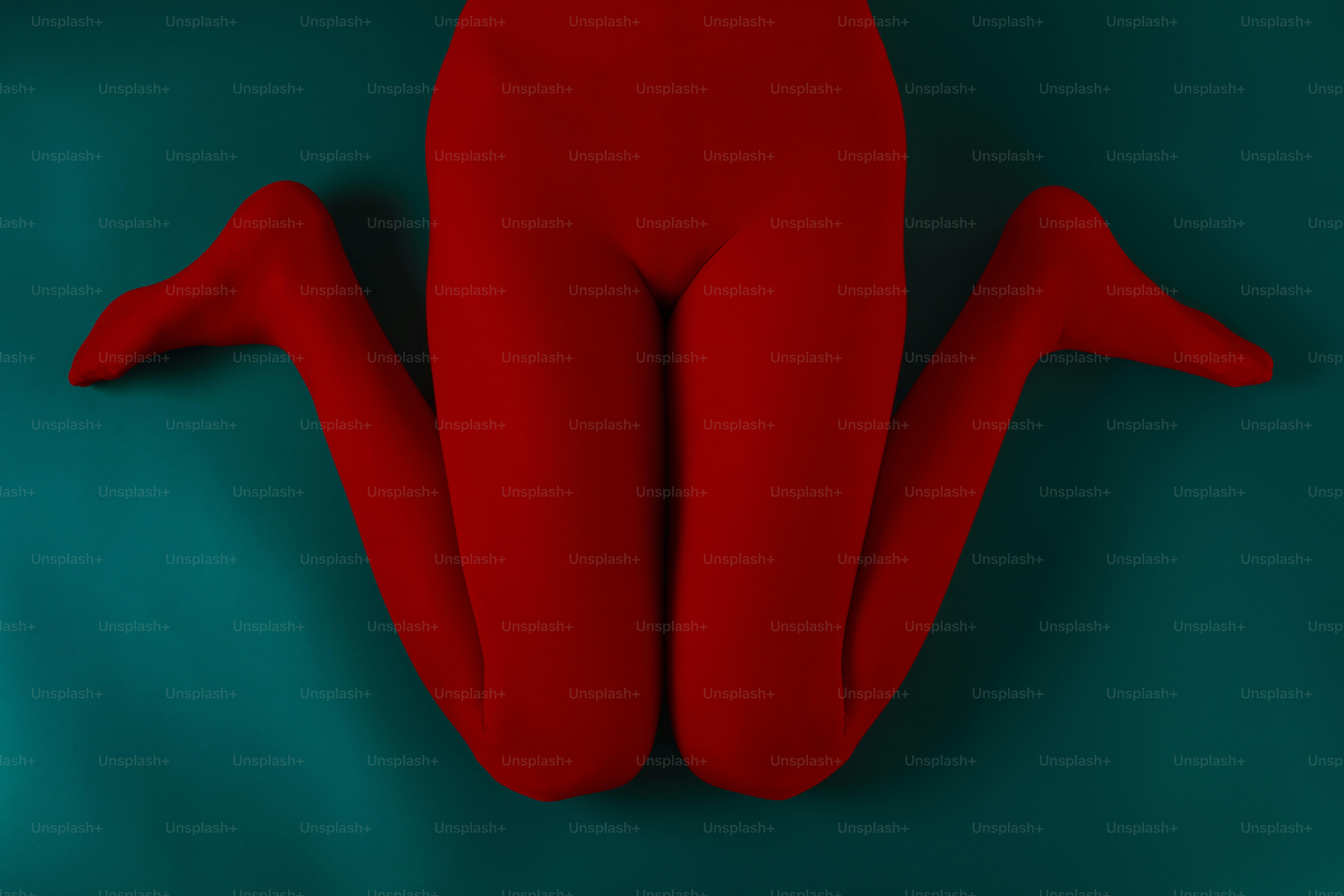 Una persona che indossa collant rossi su sfondo turchese