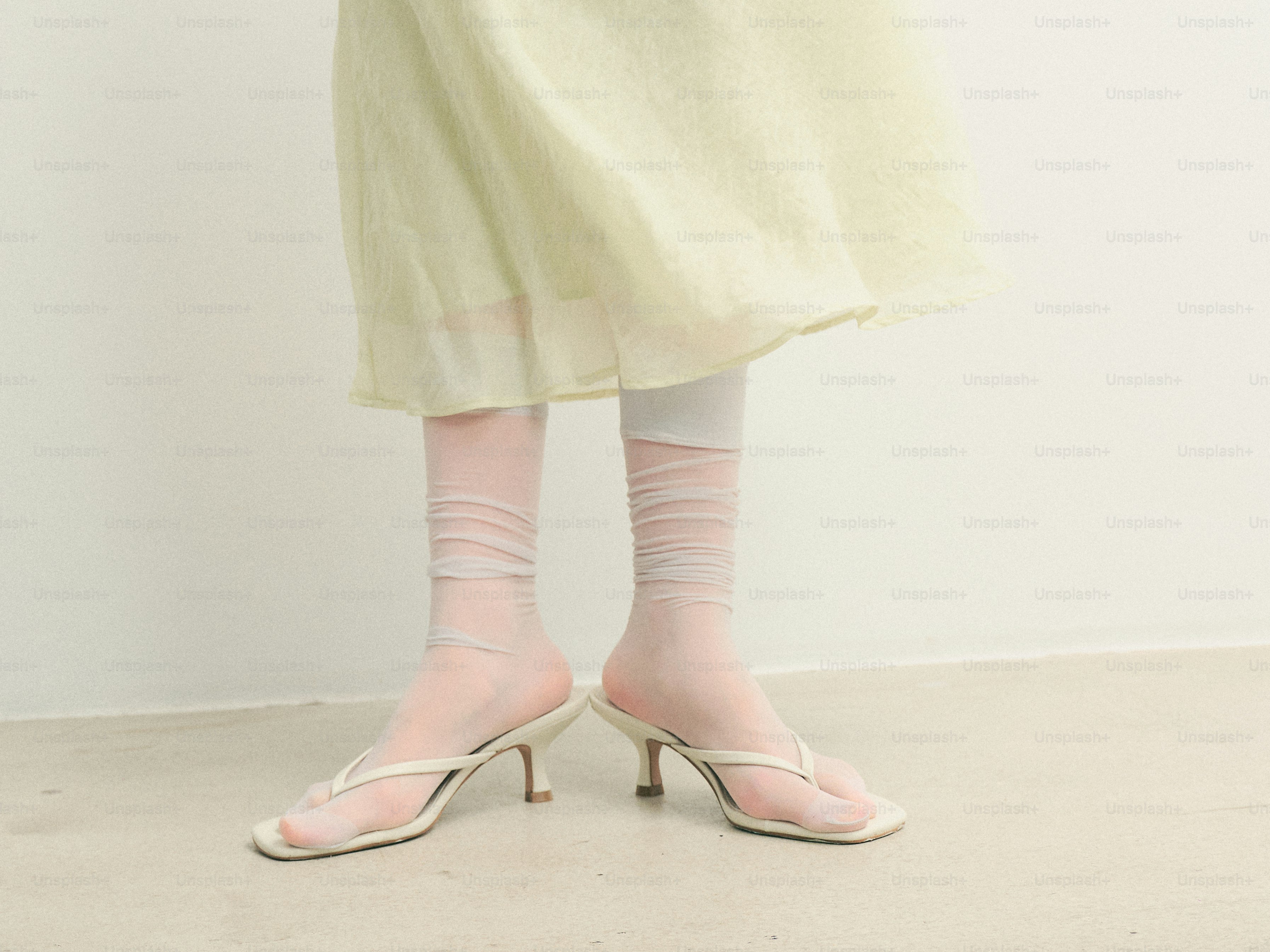 시스루 양말과 흰색 굽 샌들을 신은 여성