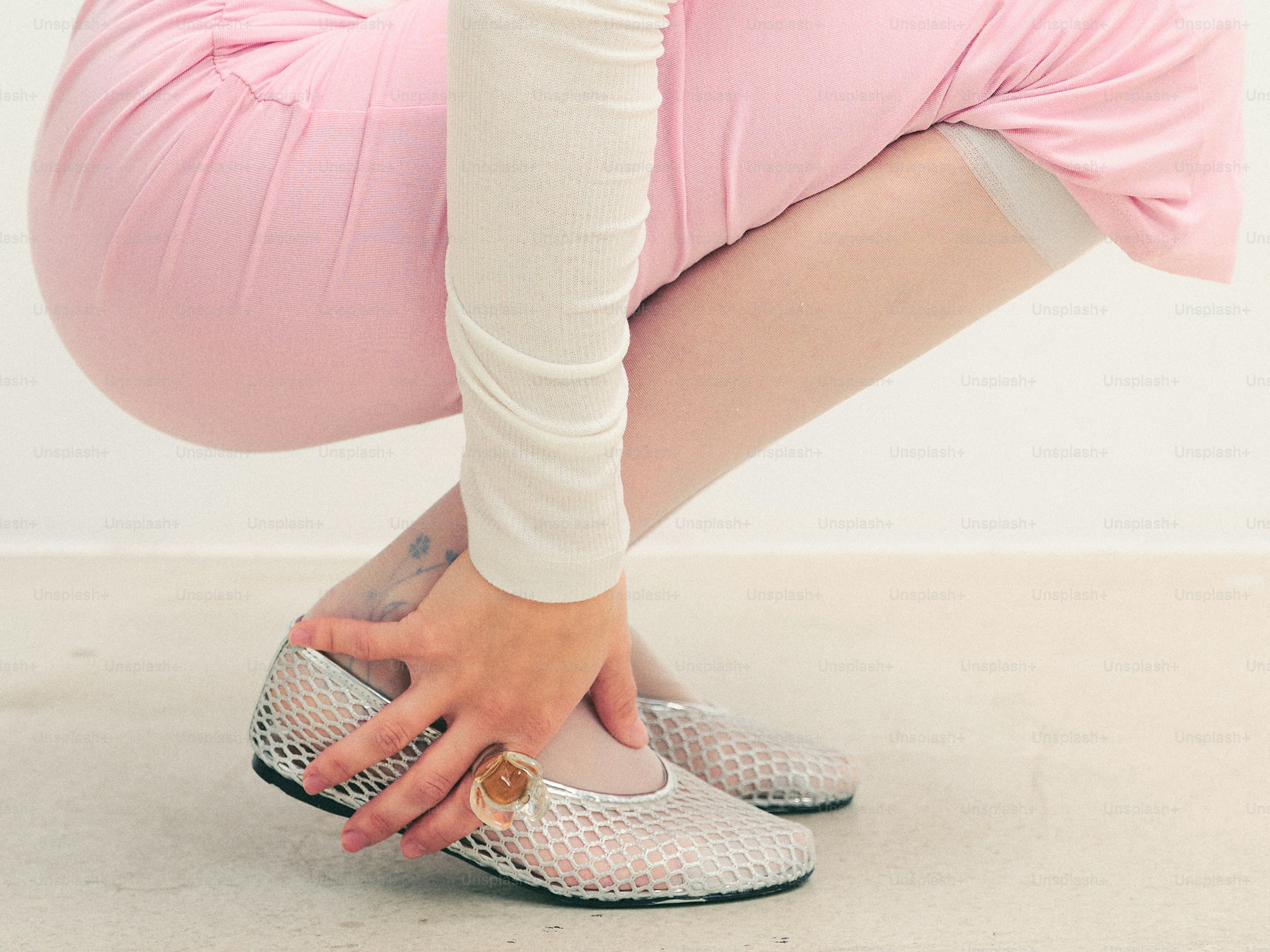 쭈그리고 앉아 은색 신발을 고쳐 입는 사람