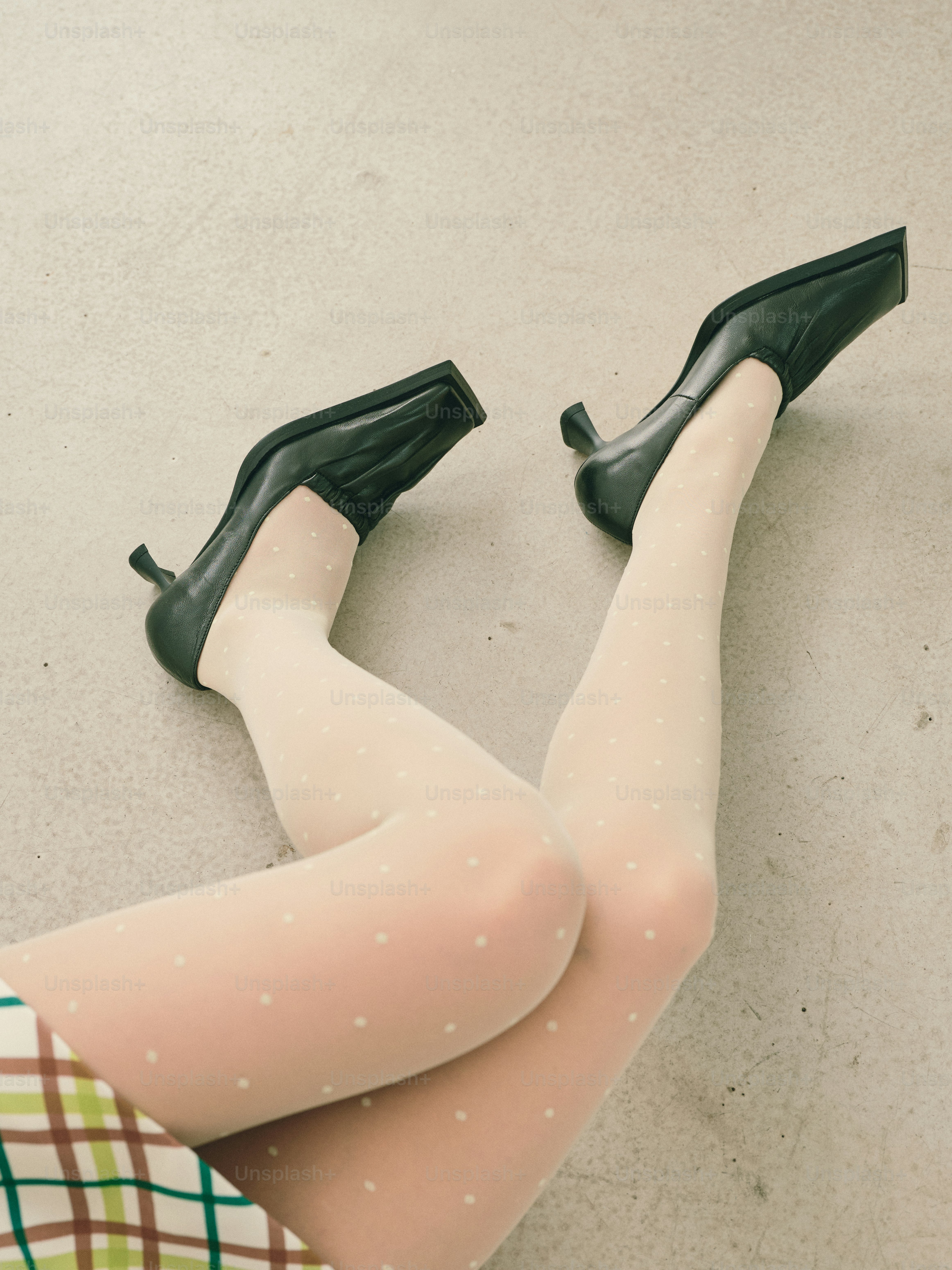 검은색 스퀘어 토 하이힐과 물방울 무늬 타이츠를 신은 여성