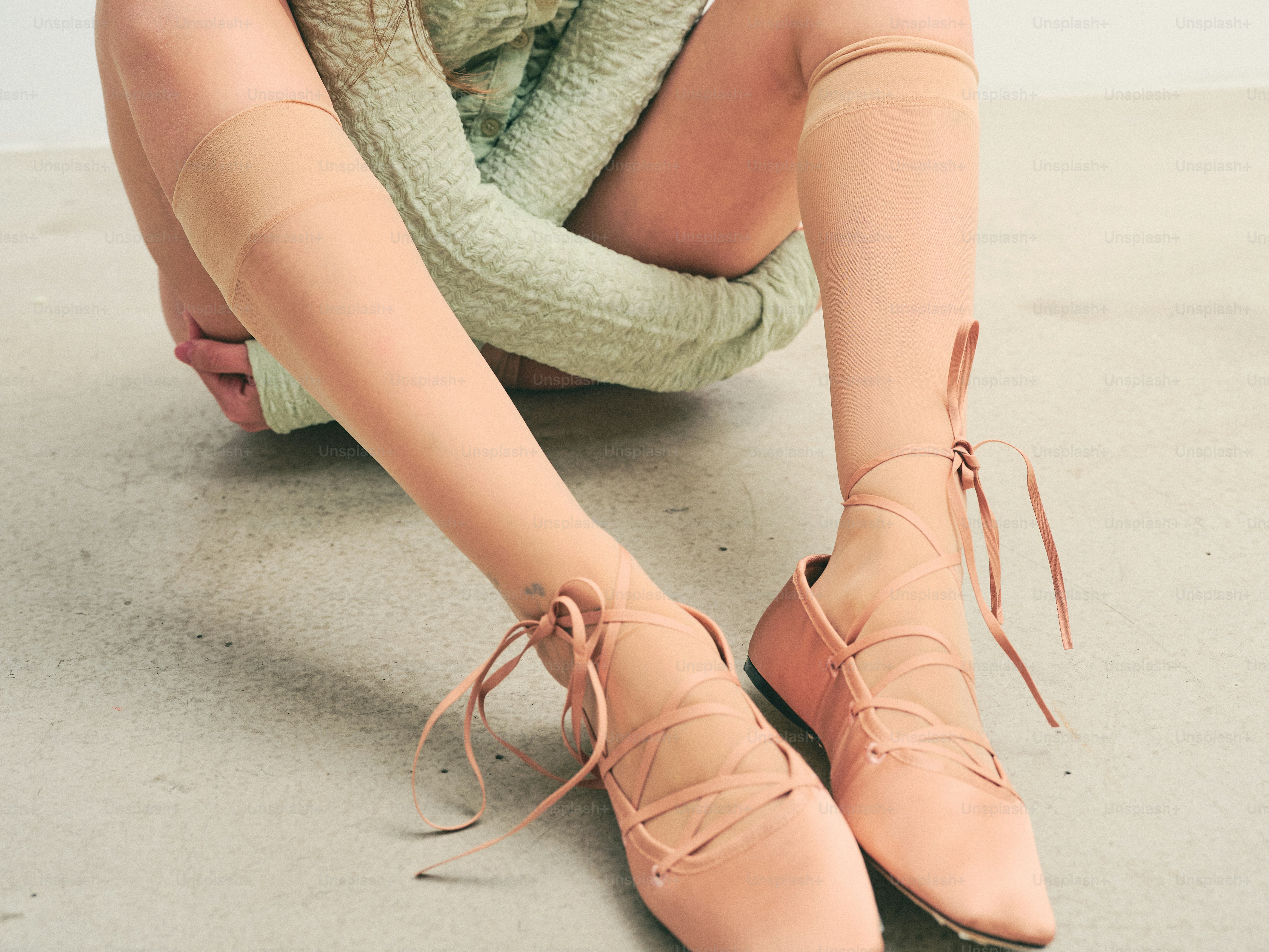 연한 분홍색 끈 끈 신발과 시스루 양말을 신은 사람.
