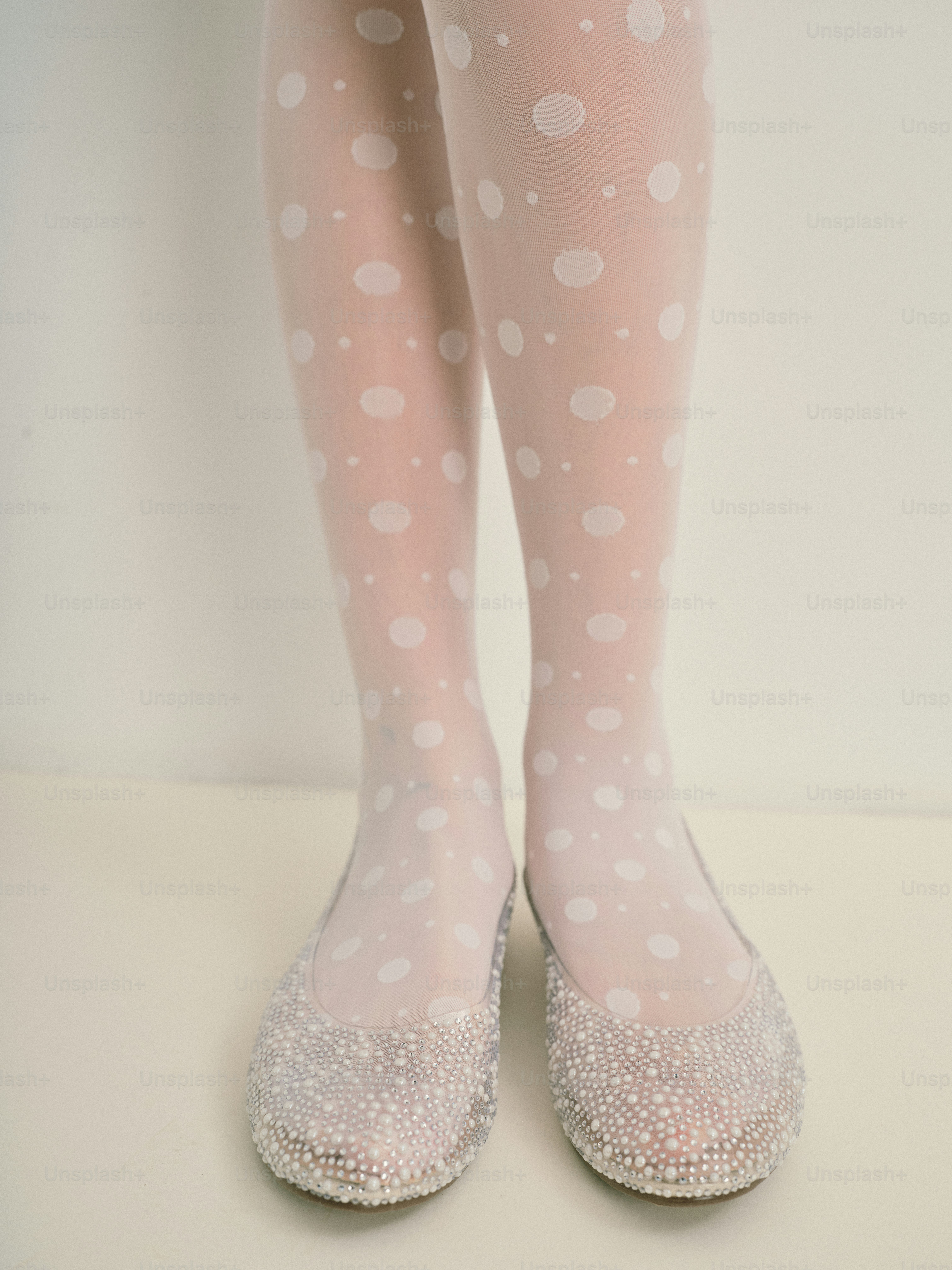 흰색 물방울 무늬 타이츠와 반짝이는 신발을 신은 사람