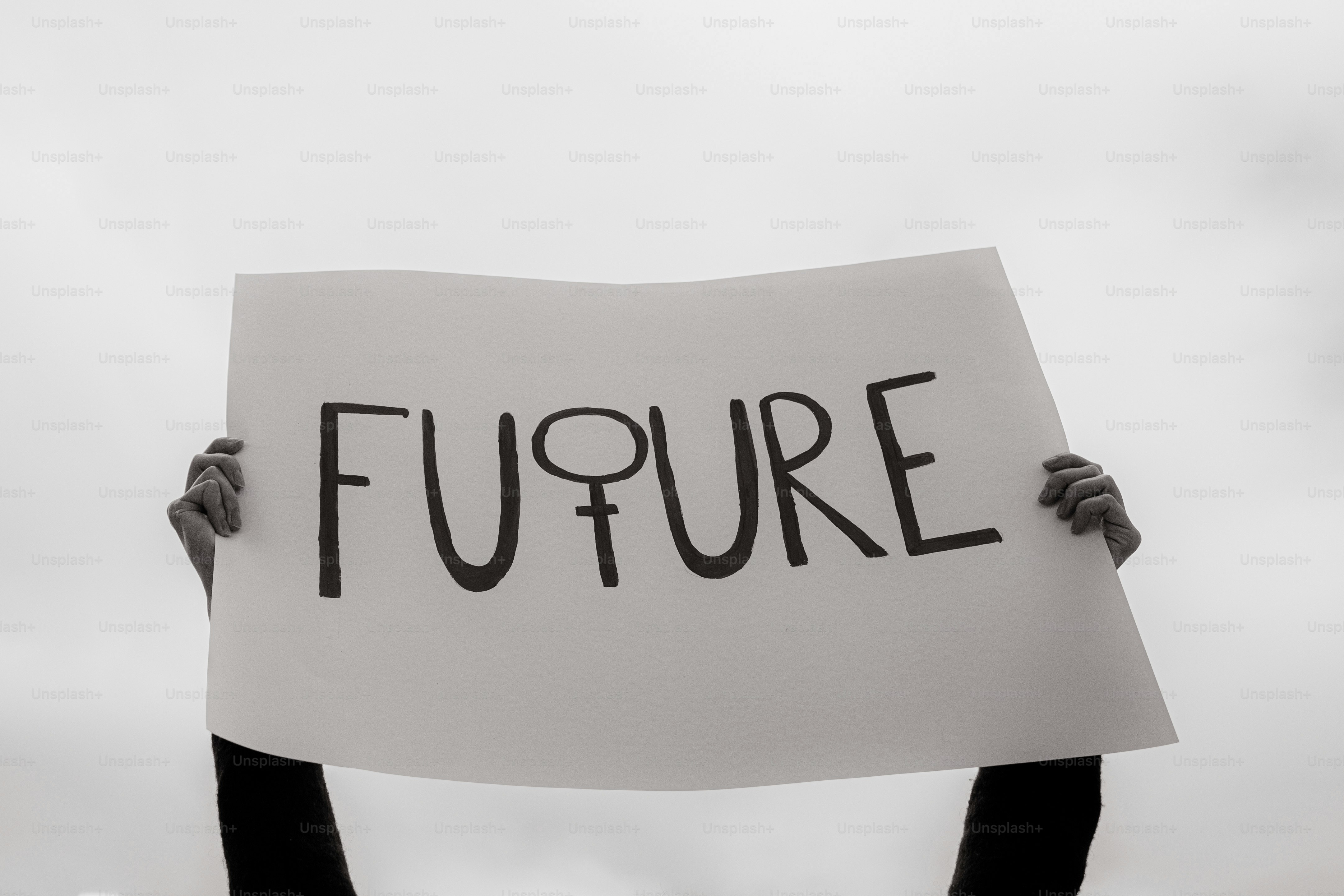 Hands hold a sign that says "future" with female symbol.