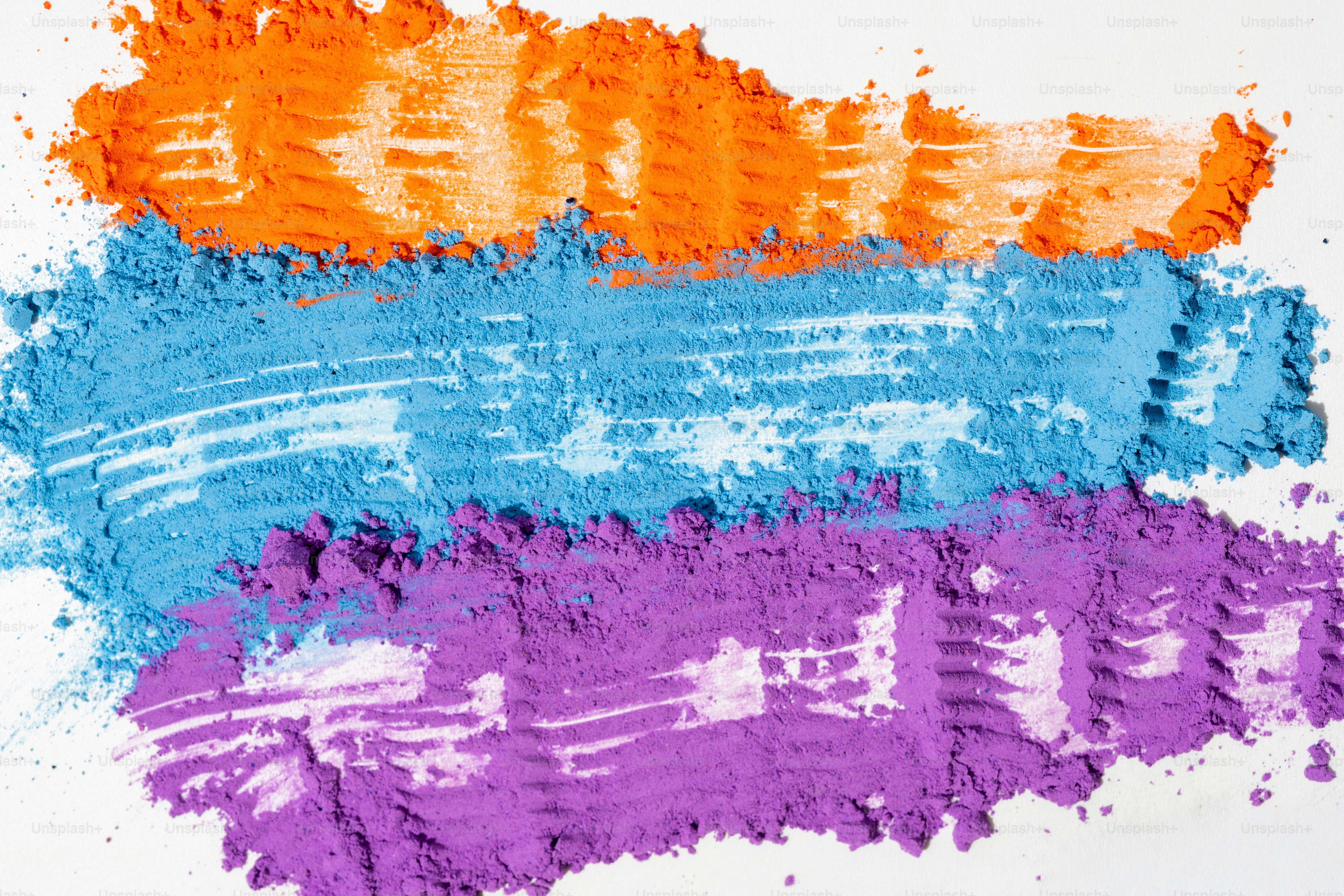 Three colorful stripes of powder on white background
