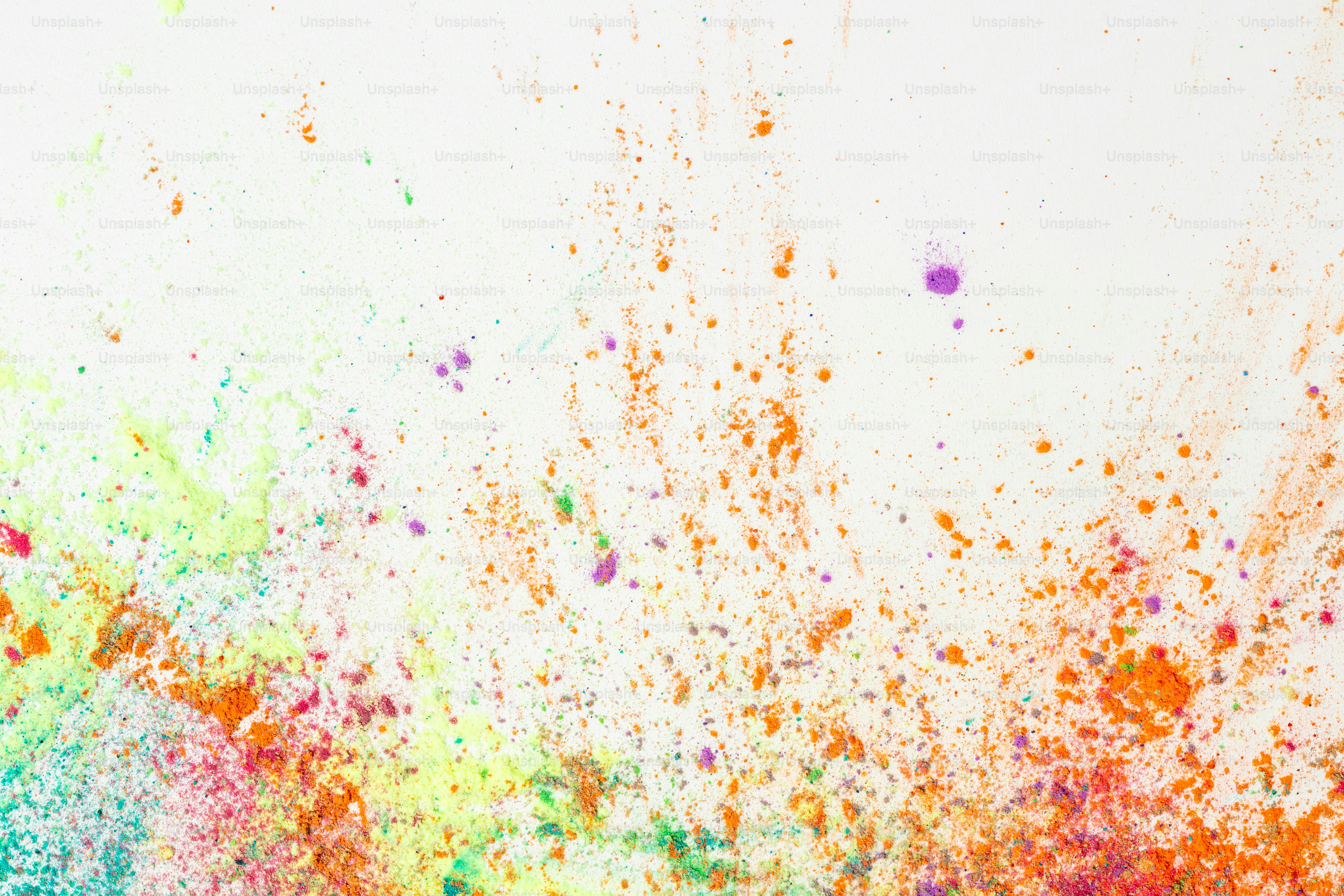 Colorful paint splatters on a white background.