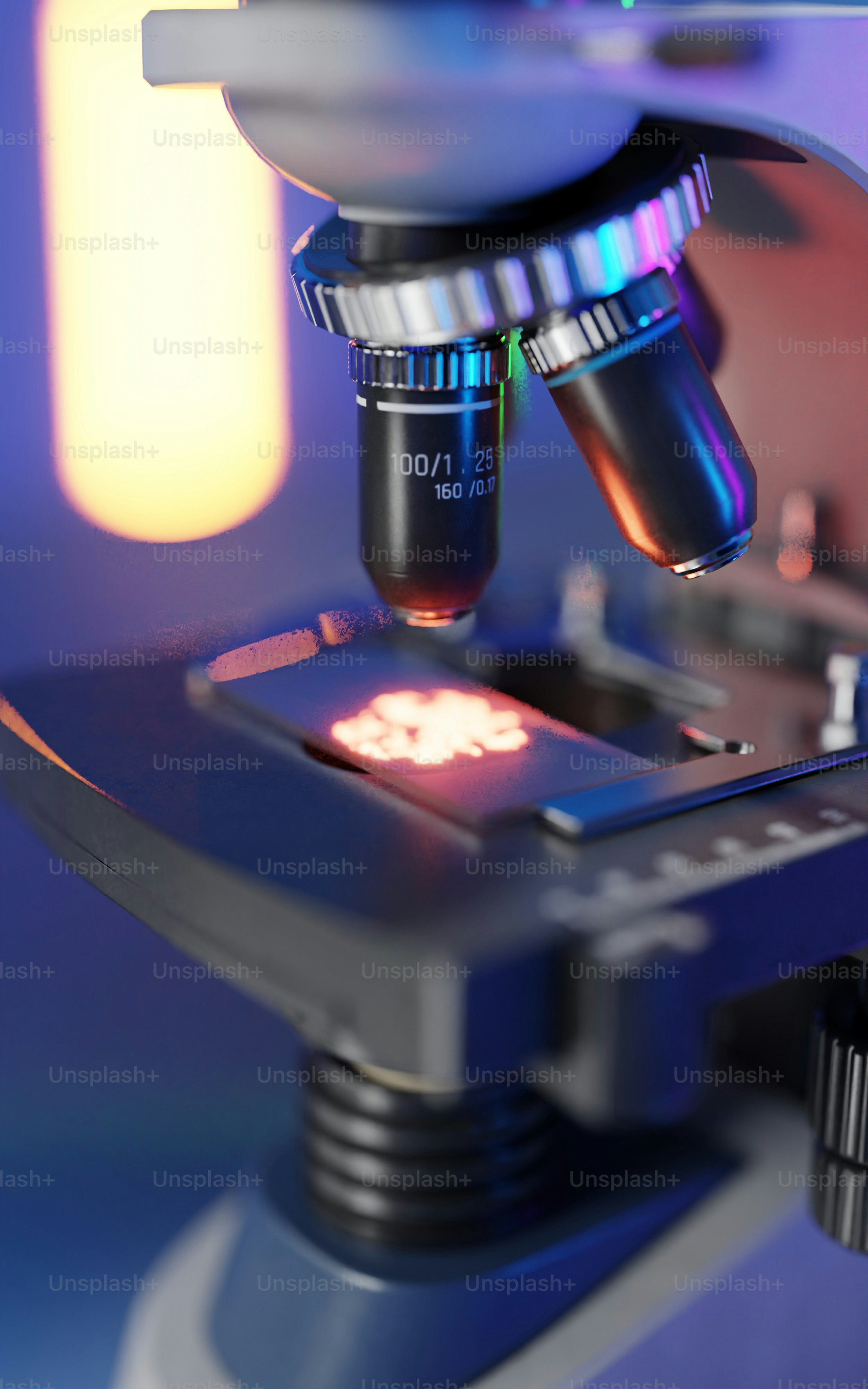 Microscope examinant un échantillon lumineux sur une lame.