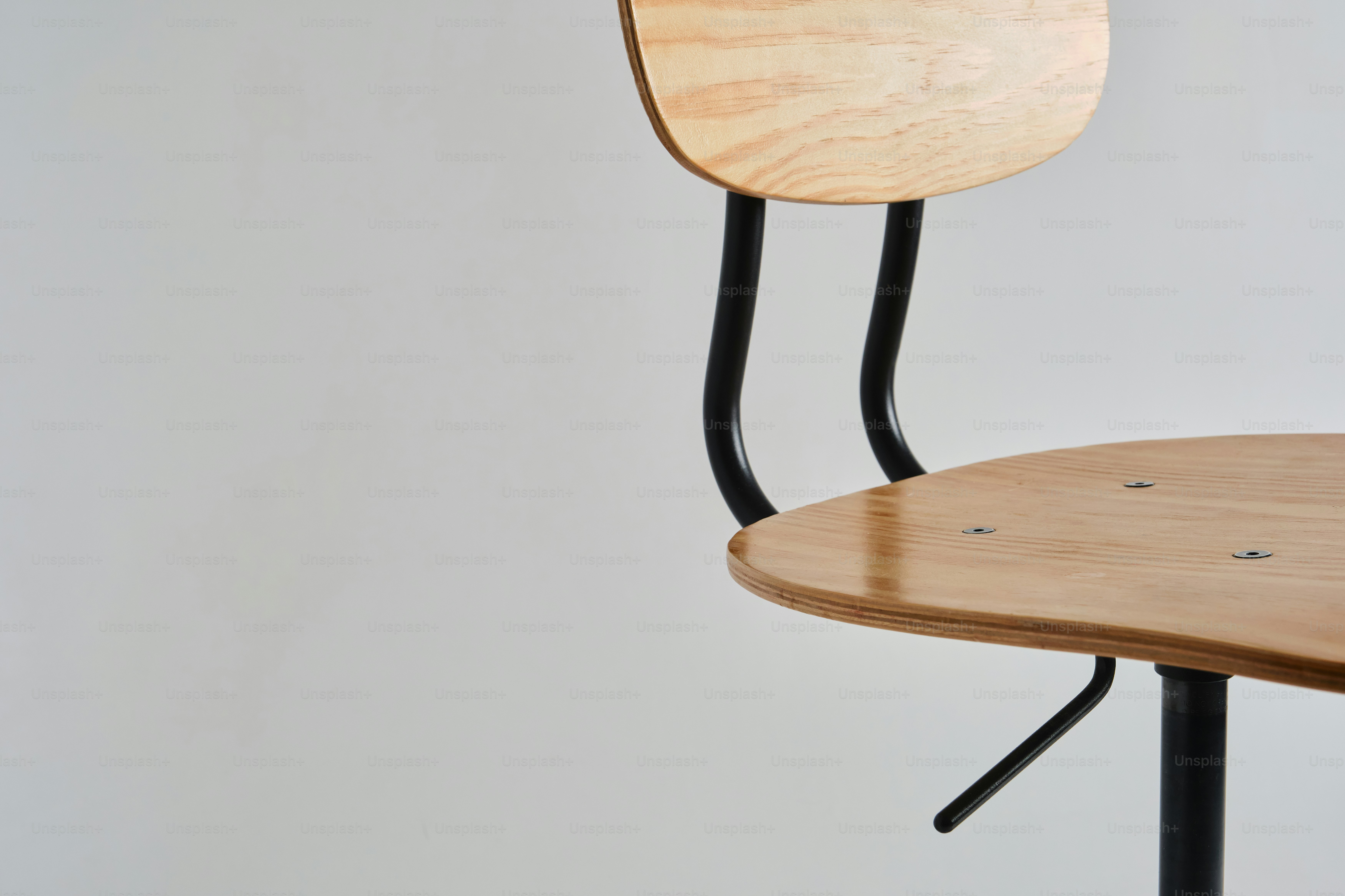 A modern wooden chair with black metal frame