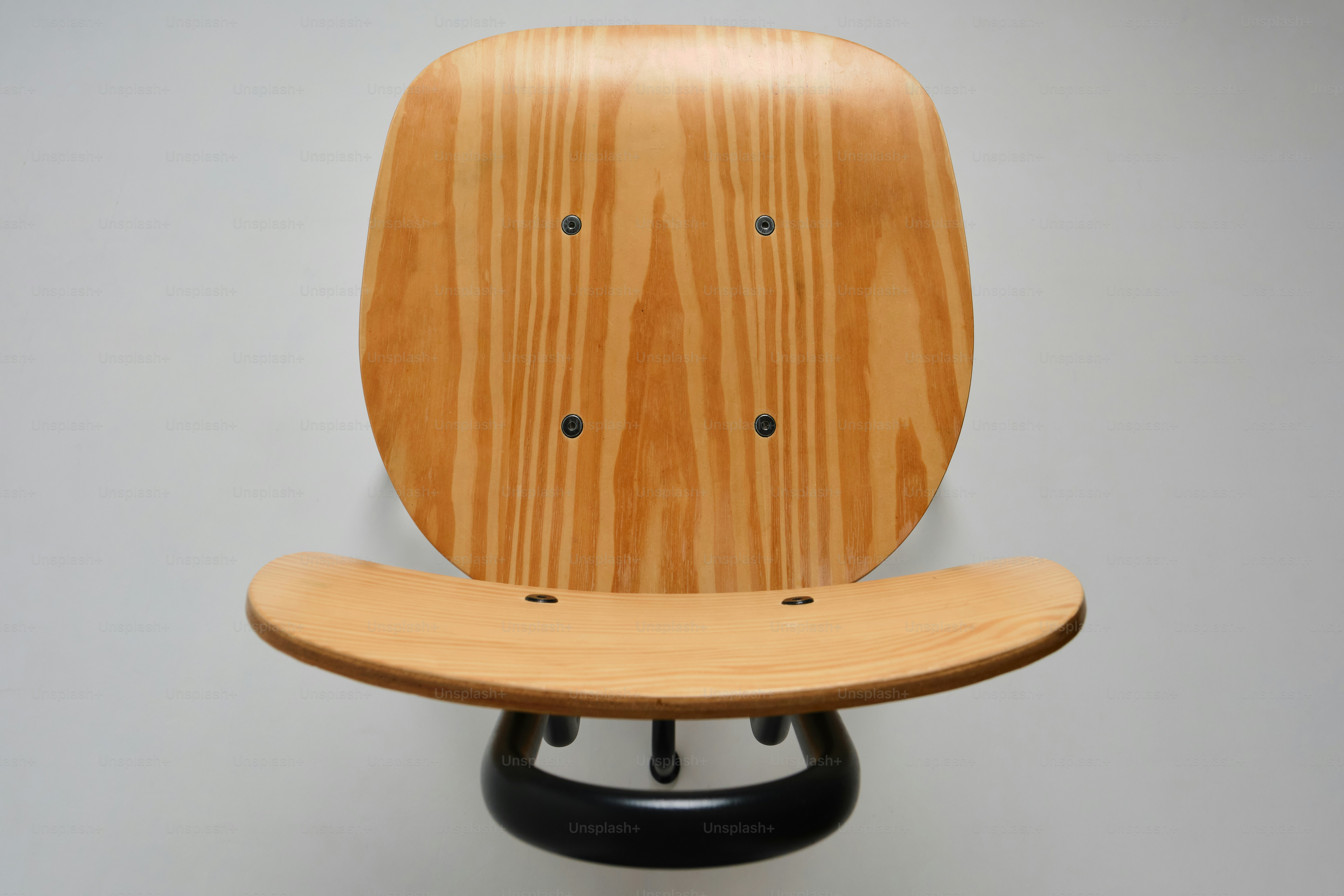 A wooden chair with a black base
