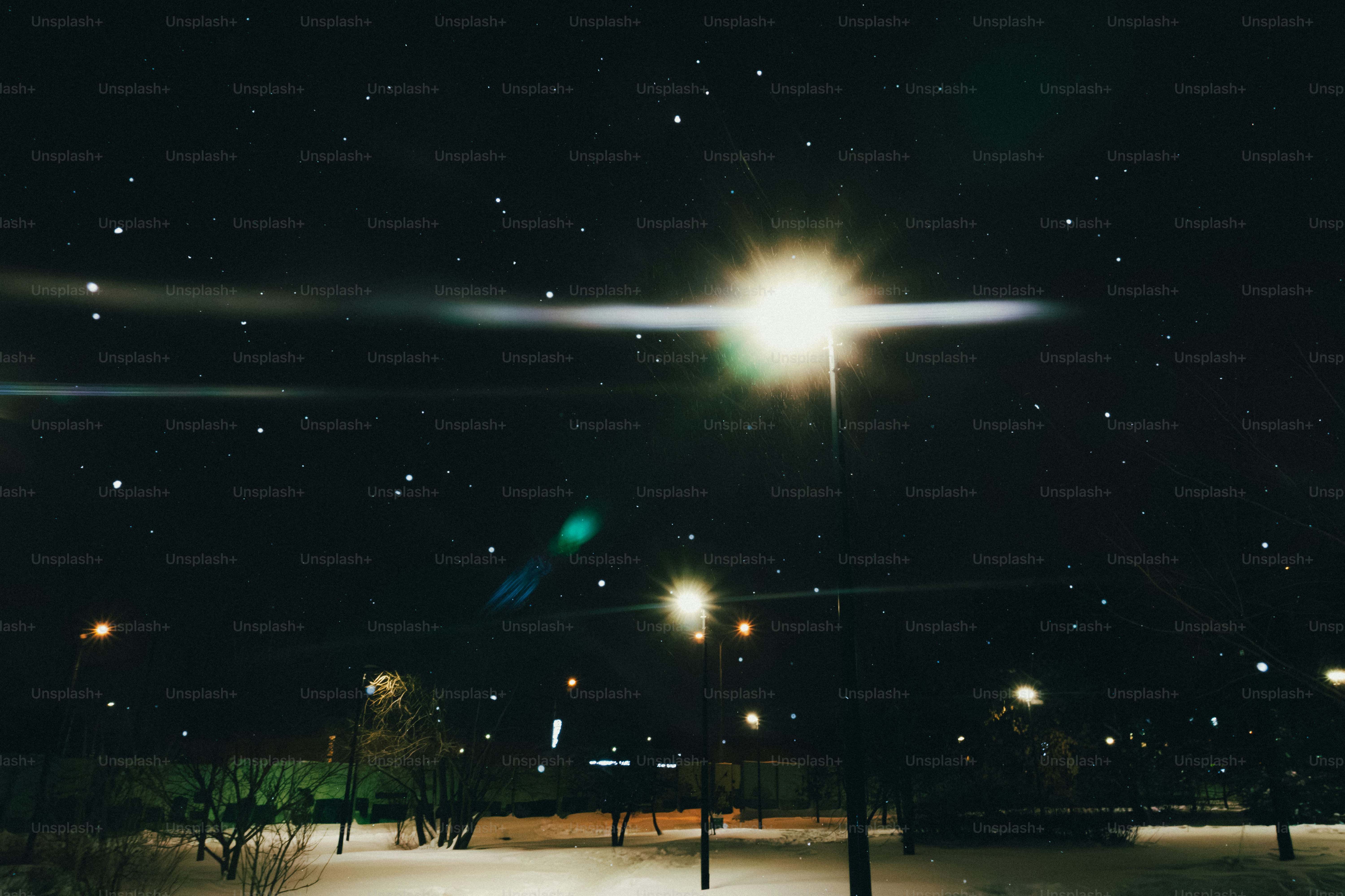 Nachthimmel mit hellen Lichtern und fallendem Schnee