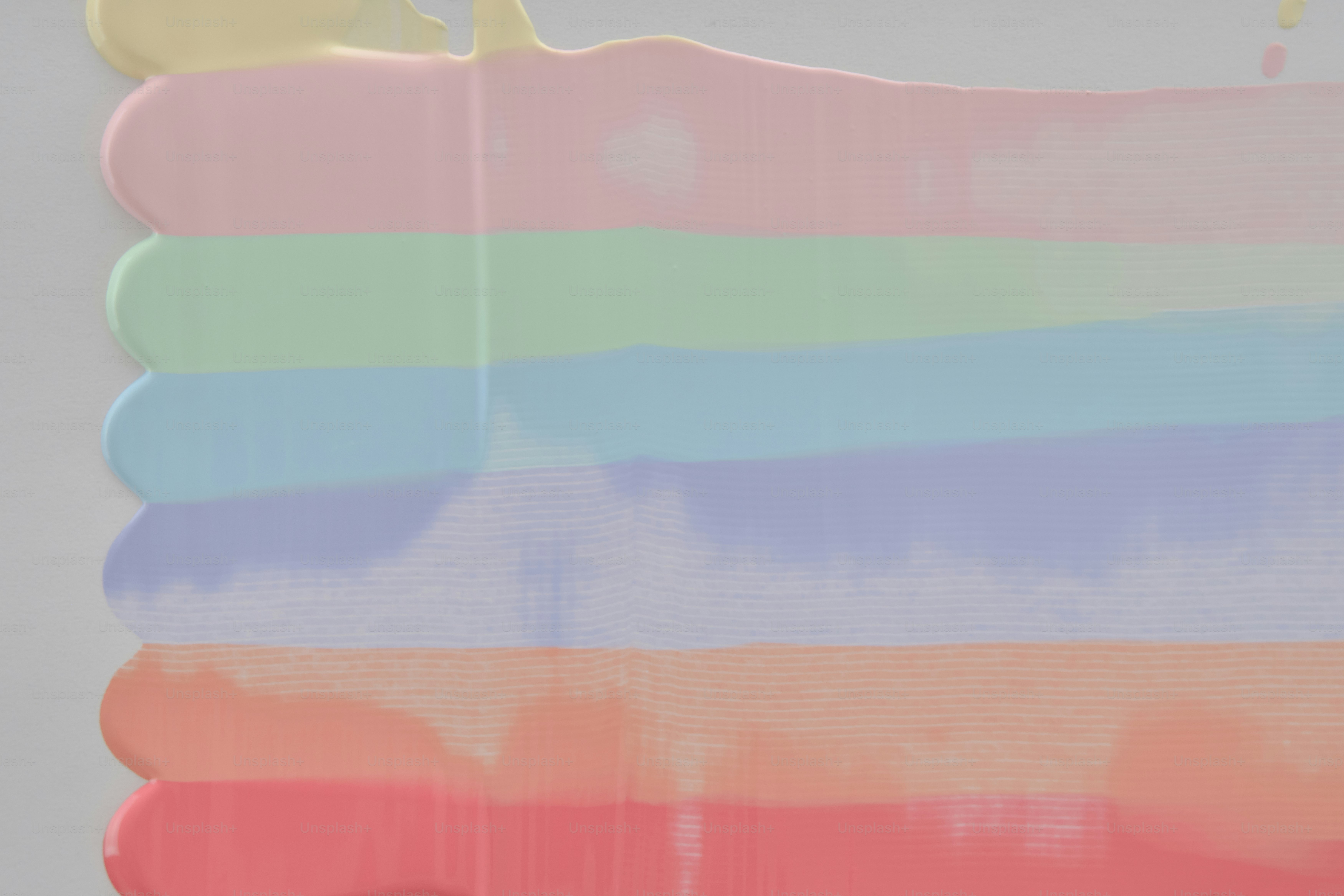 Pastel rainbow colors dripping down a white surface