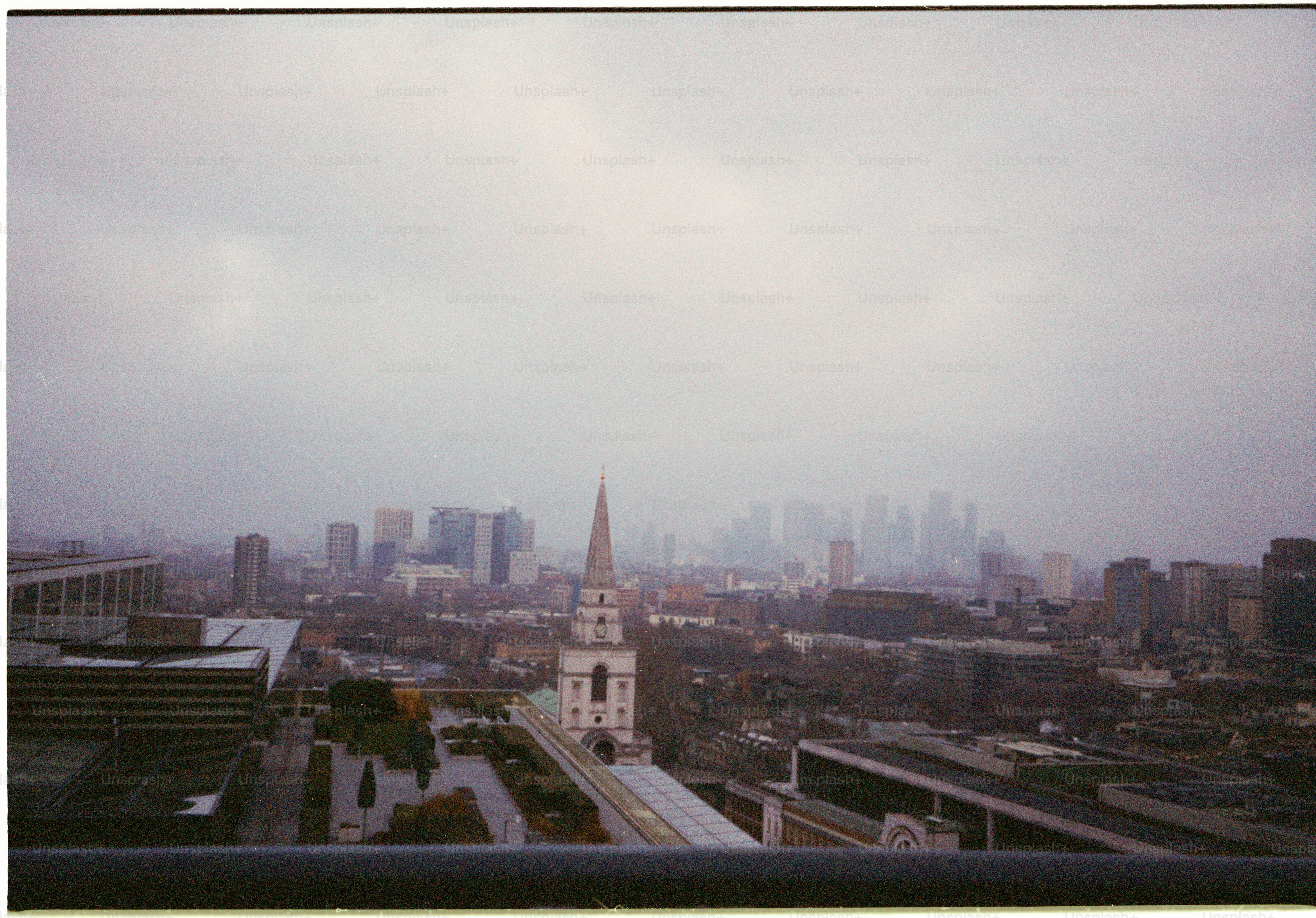 City skyline with a church steeple on a foggy day.