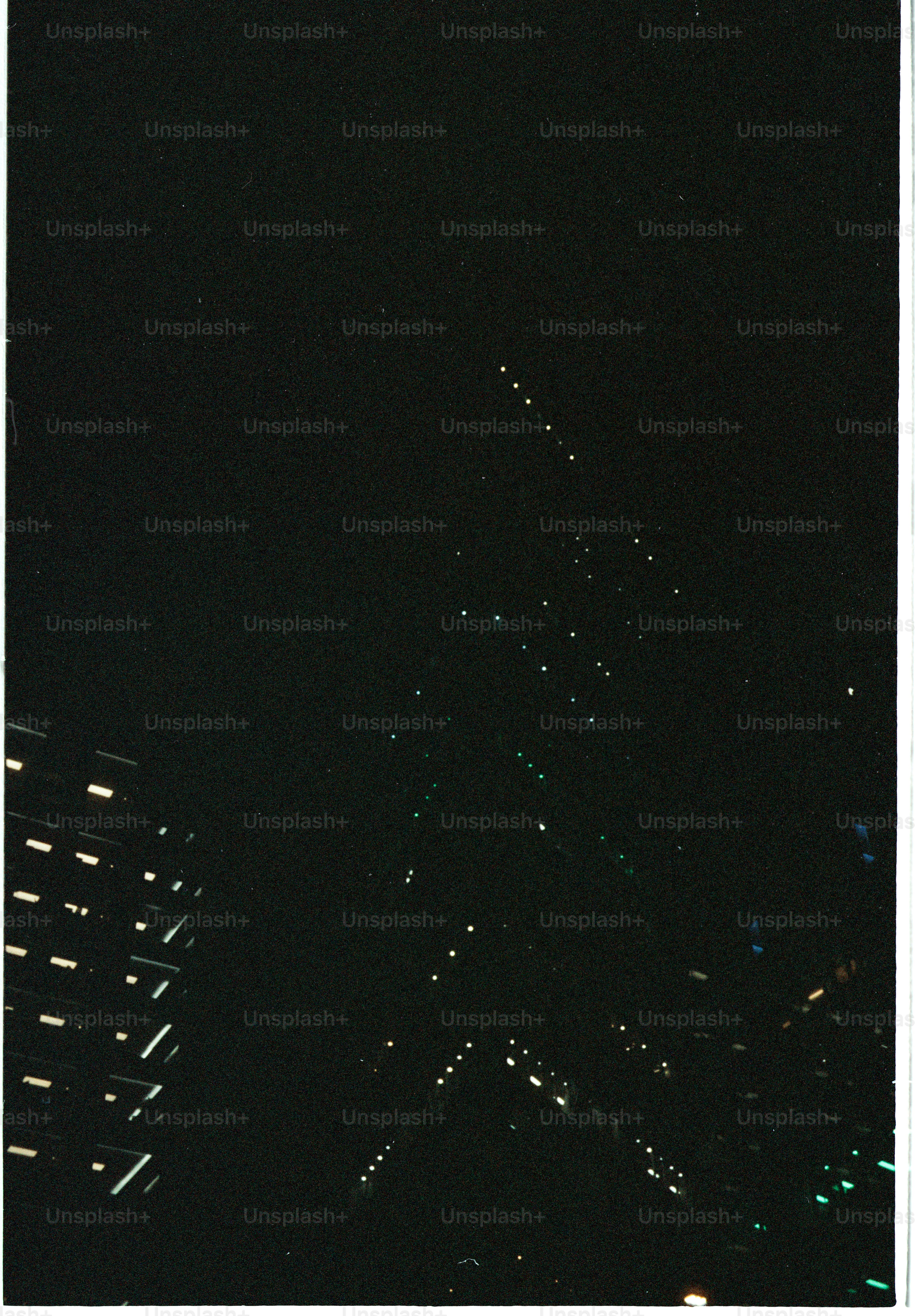 Distant city lights twinkle in the dark night sky.