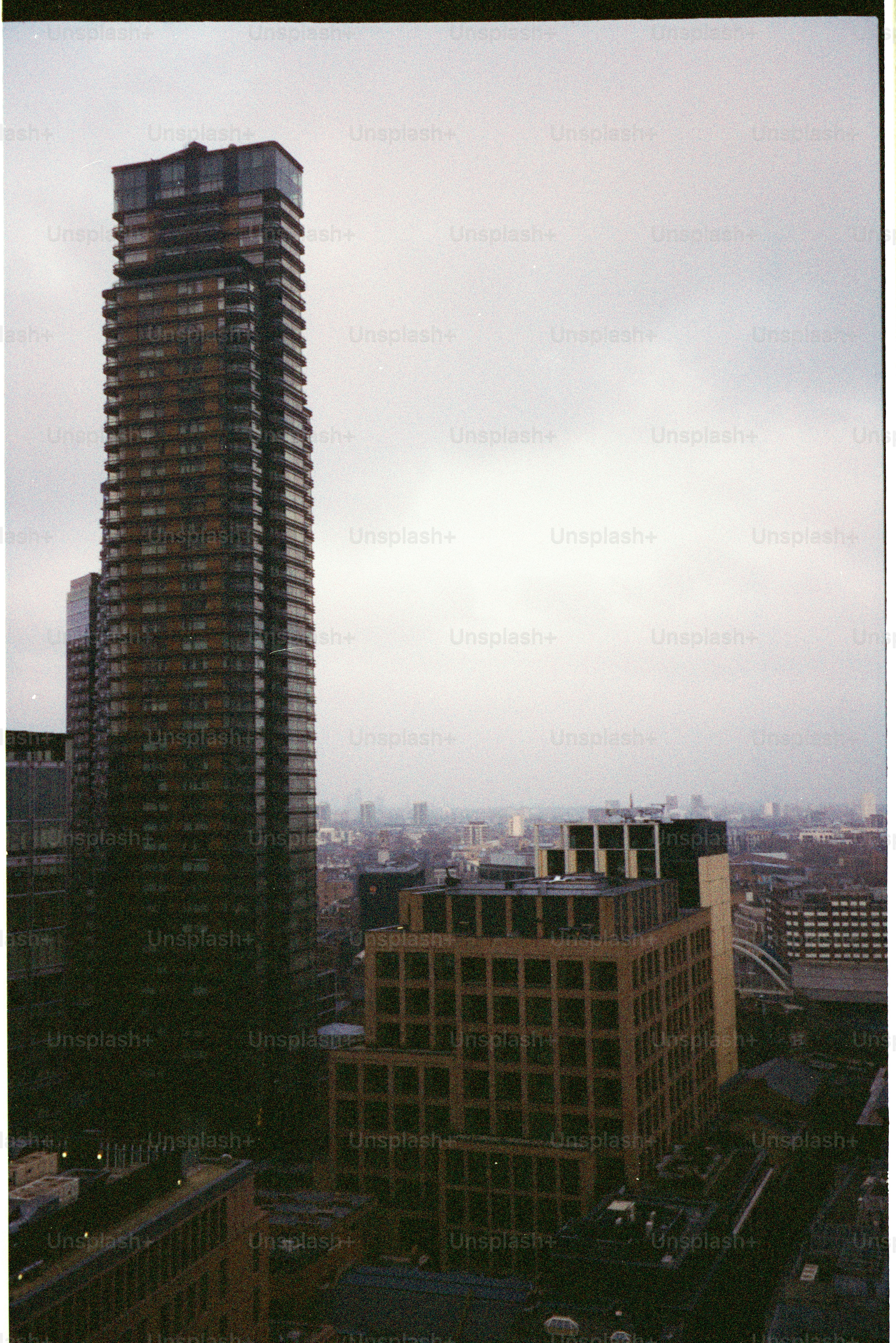Tall modern skyscraper against a cloudy sky.