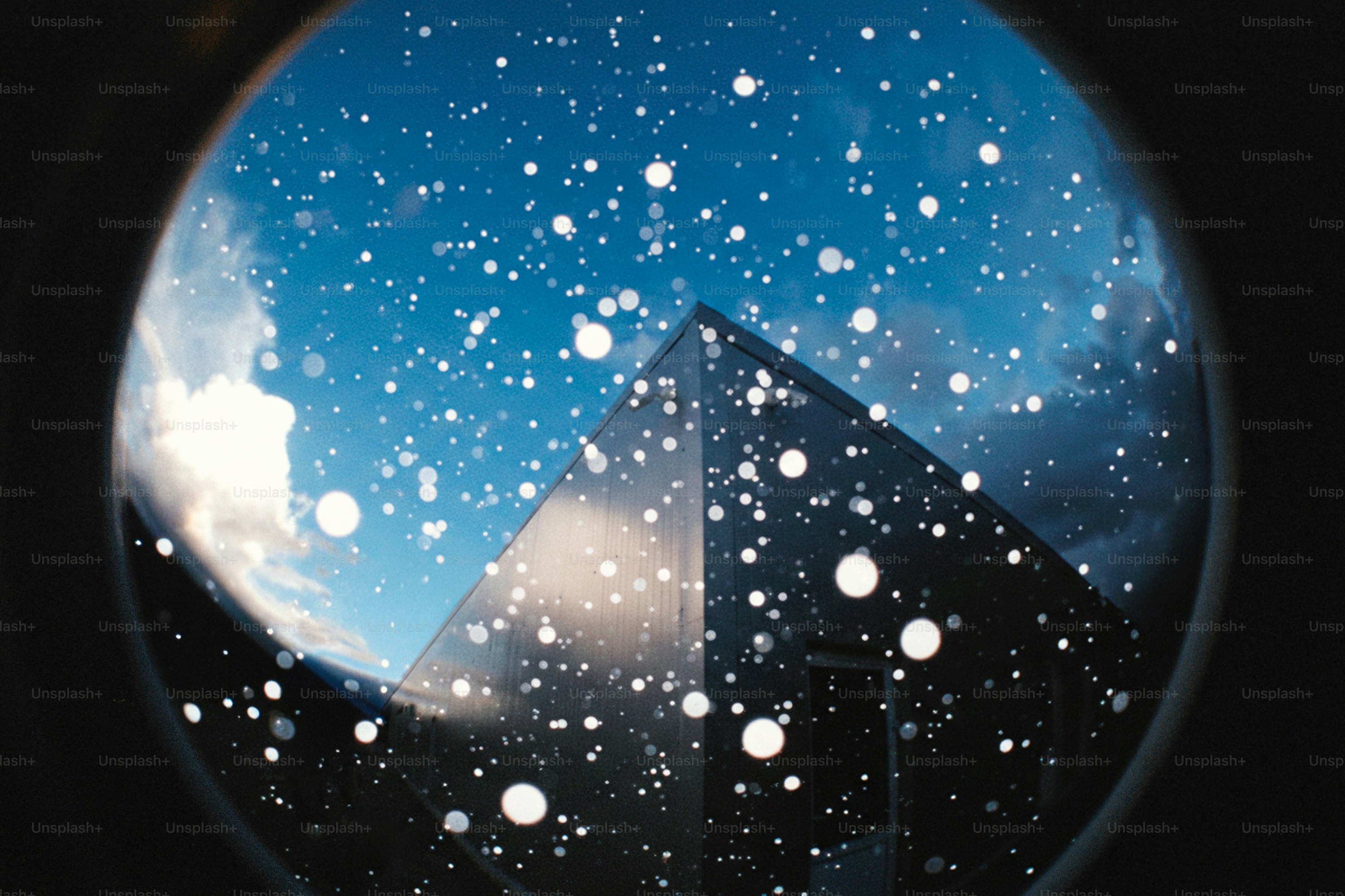 Snowflakes fall against a pyramid and sky.