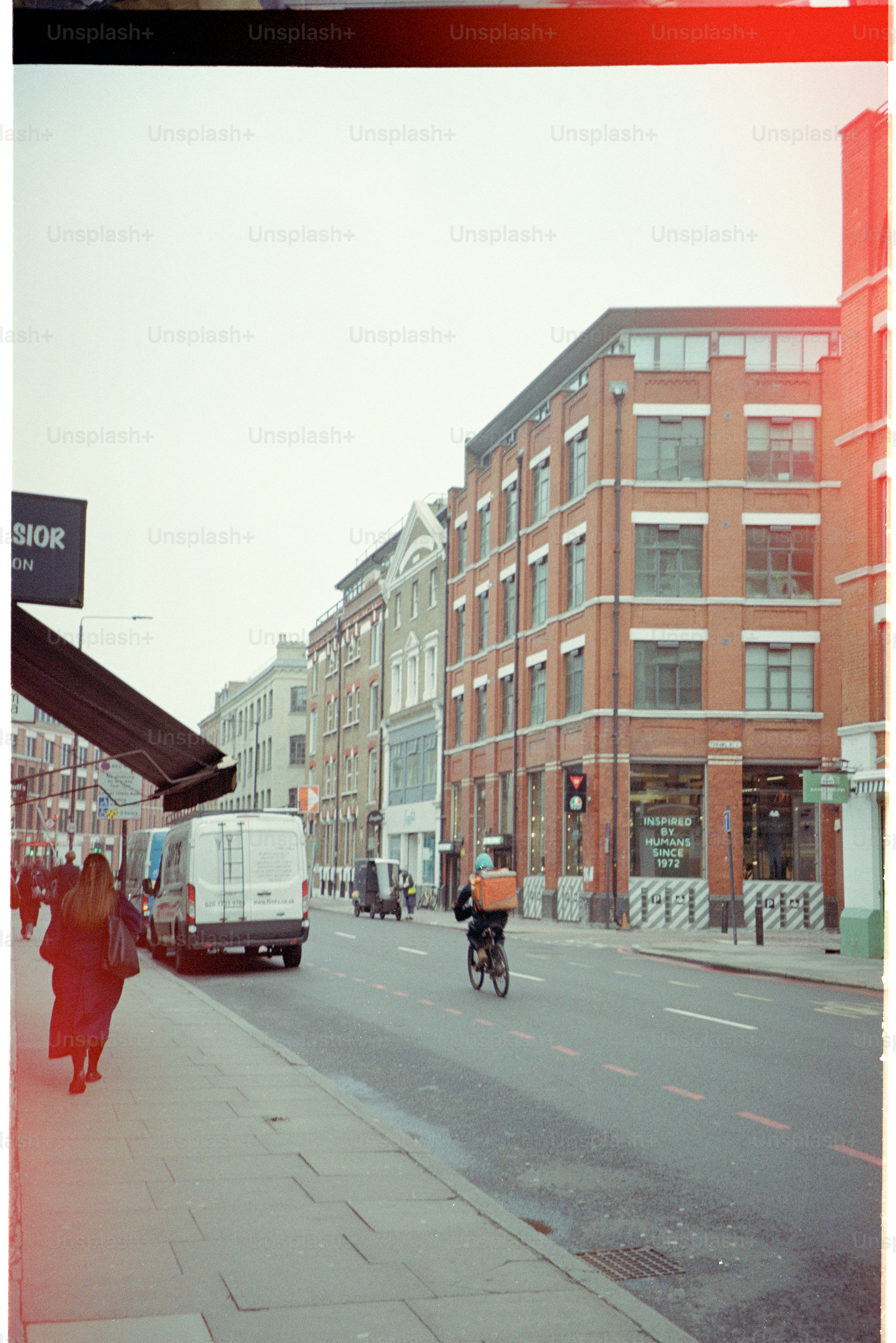 A delivery cyclist rides down a city street.