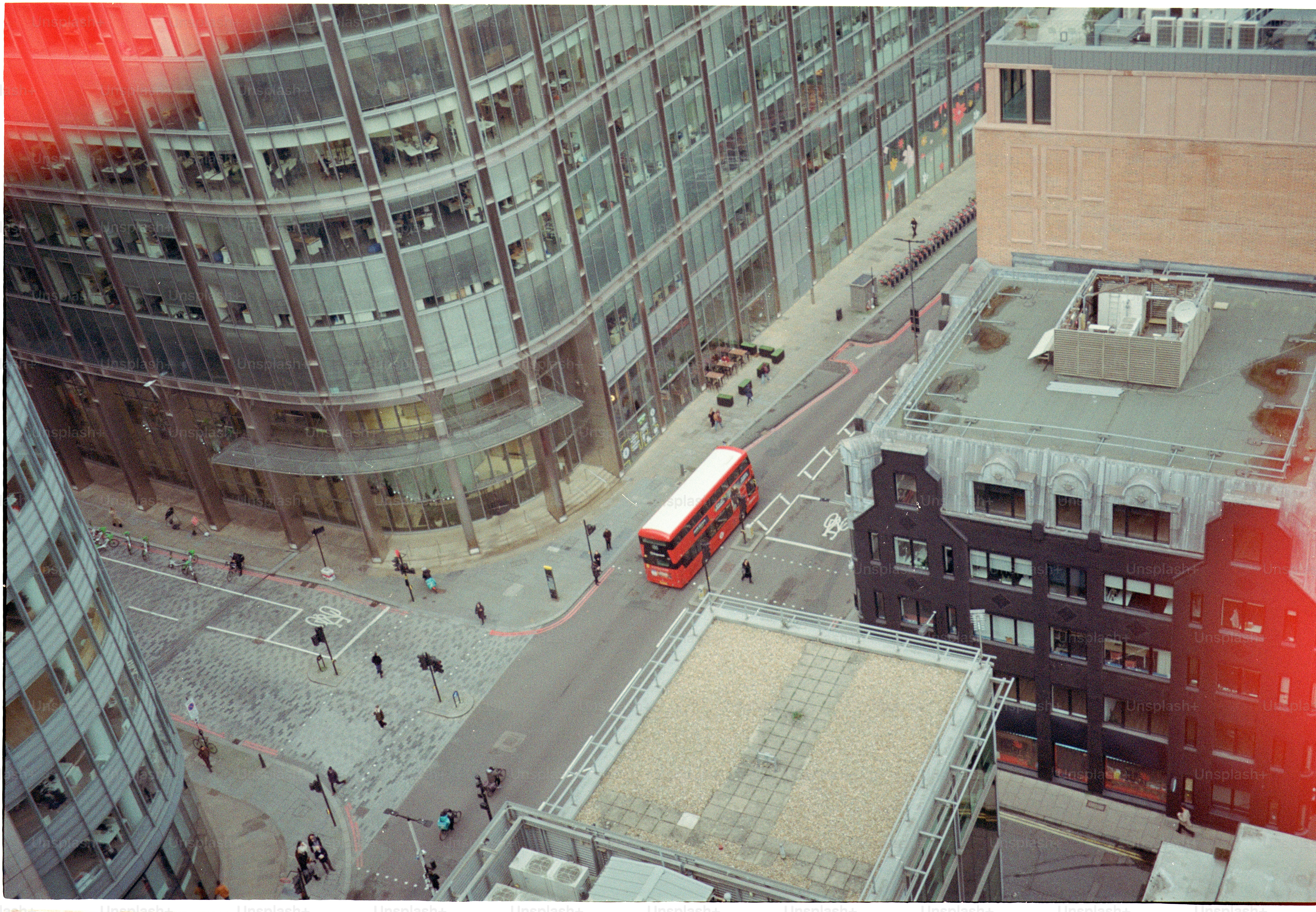 Red double-decker bus driving on city street.