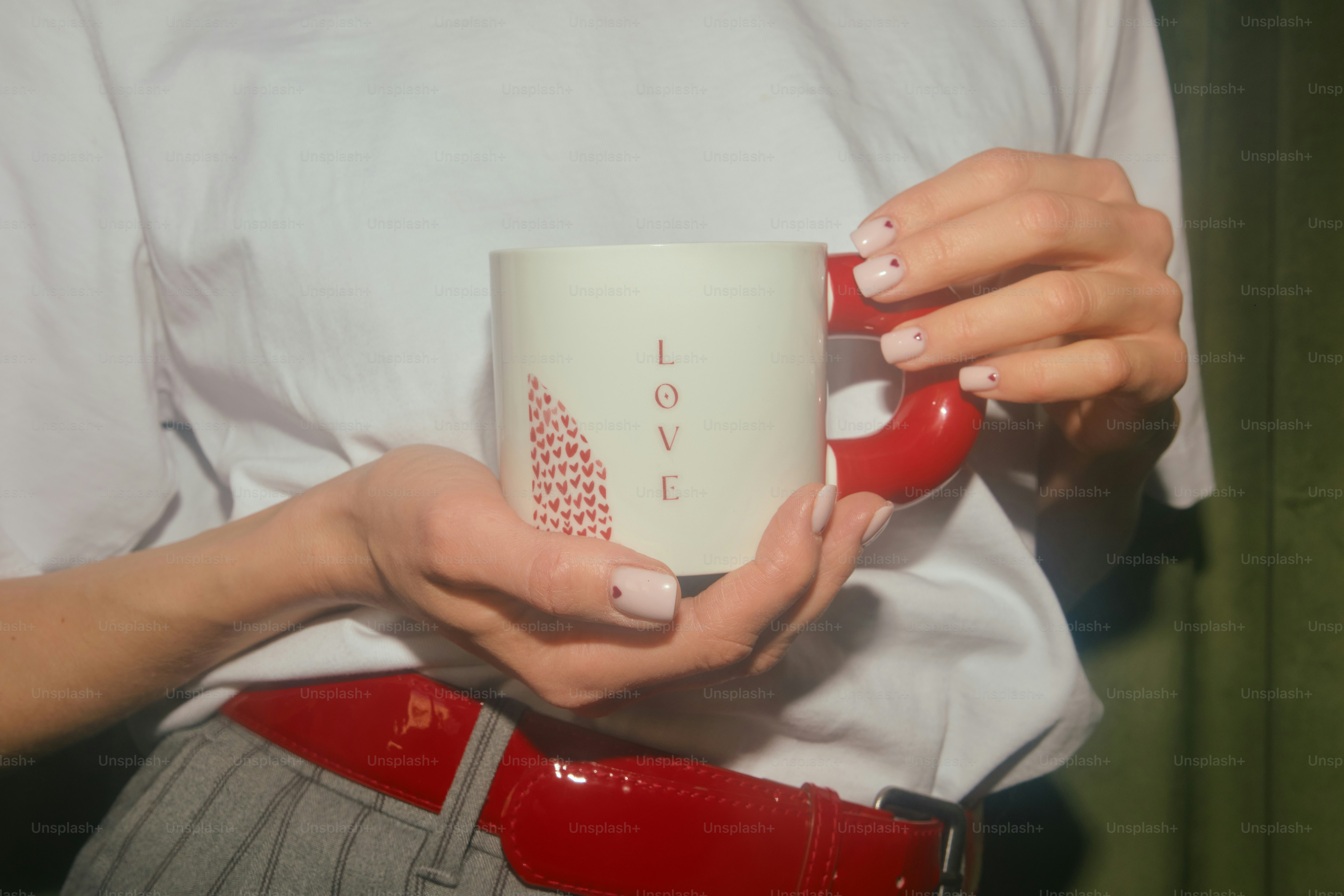 Frau hält eine Tasse mit dem Wort Liebe