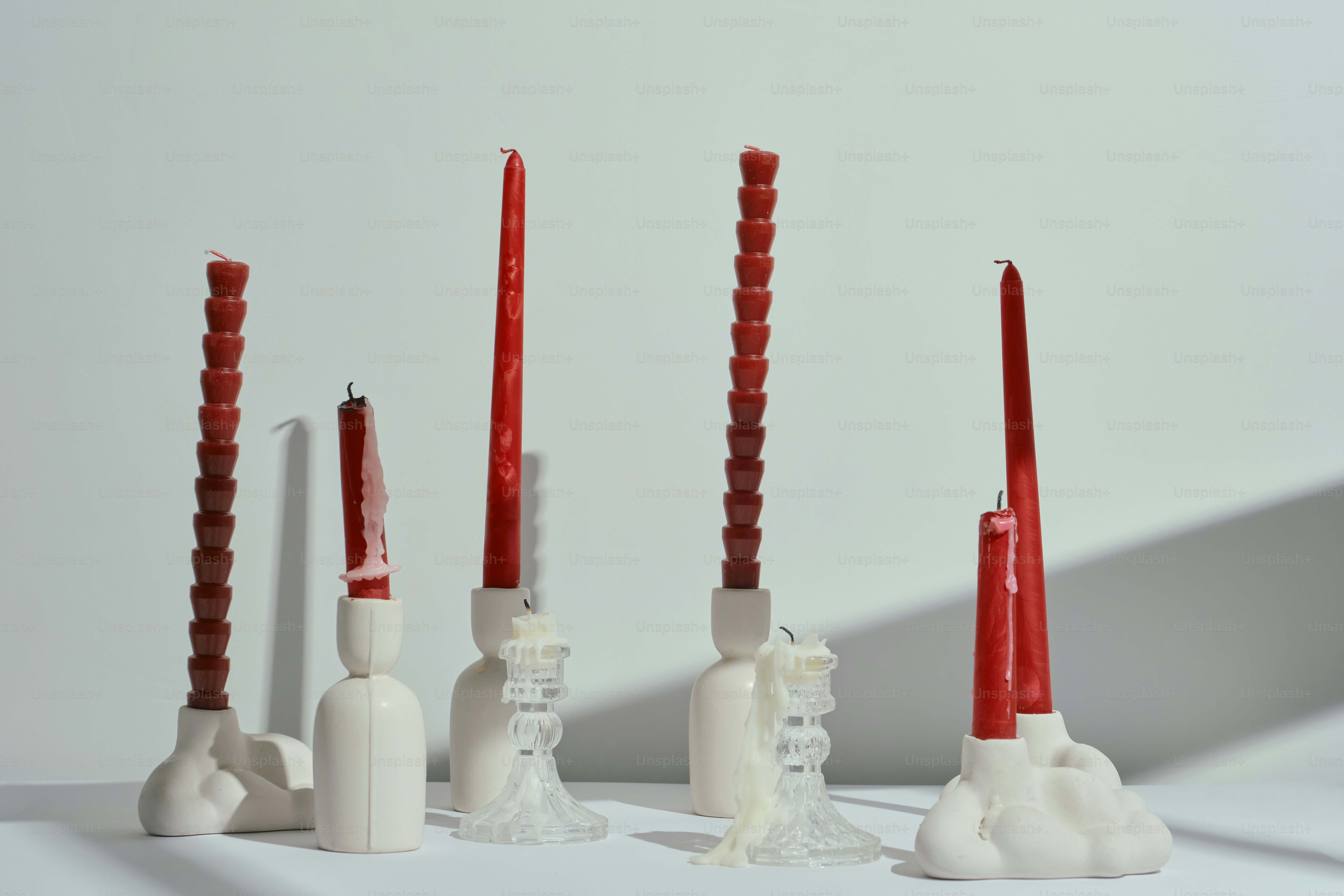 Fünf dekorative Kerzen auf weißen Haltern