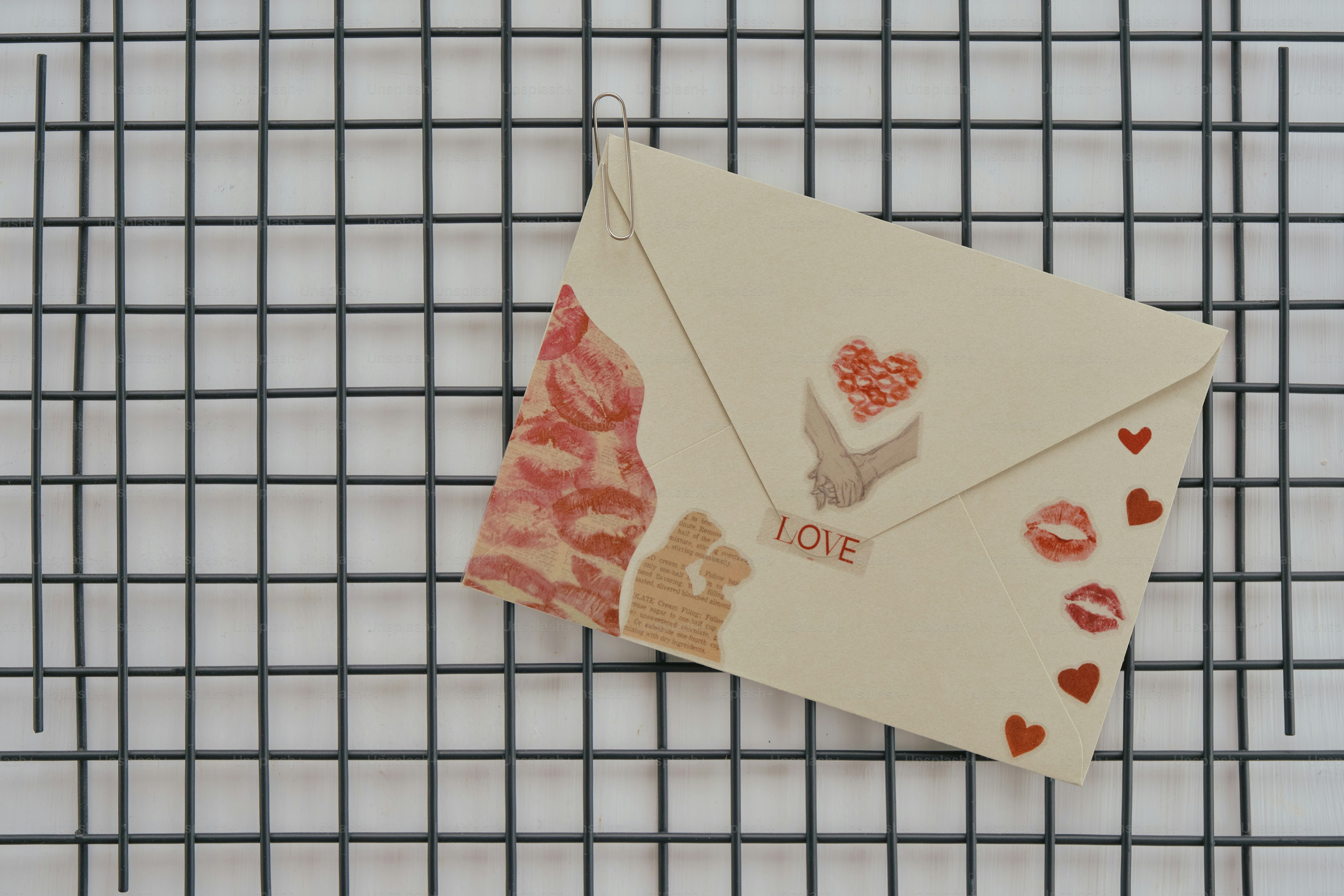 Ein cremefarbener Umschlag, verziert mit Herzen und Küssen