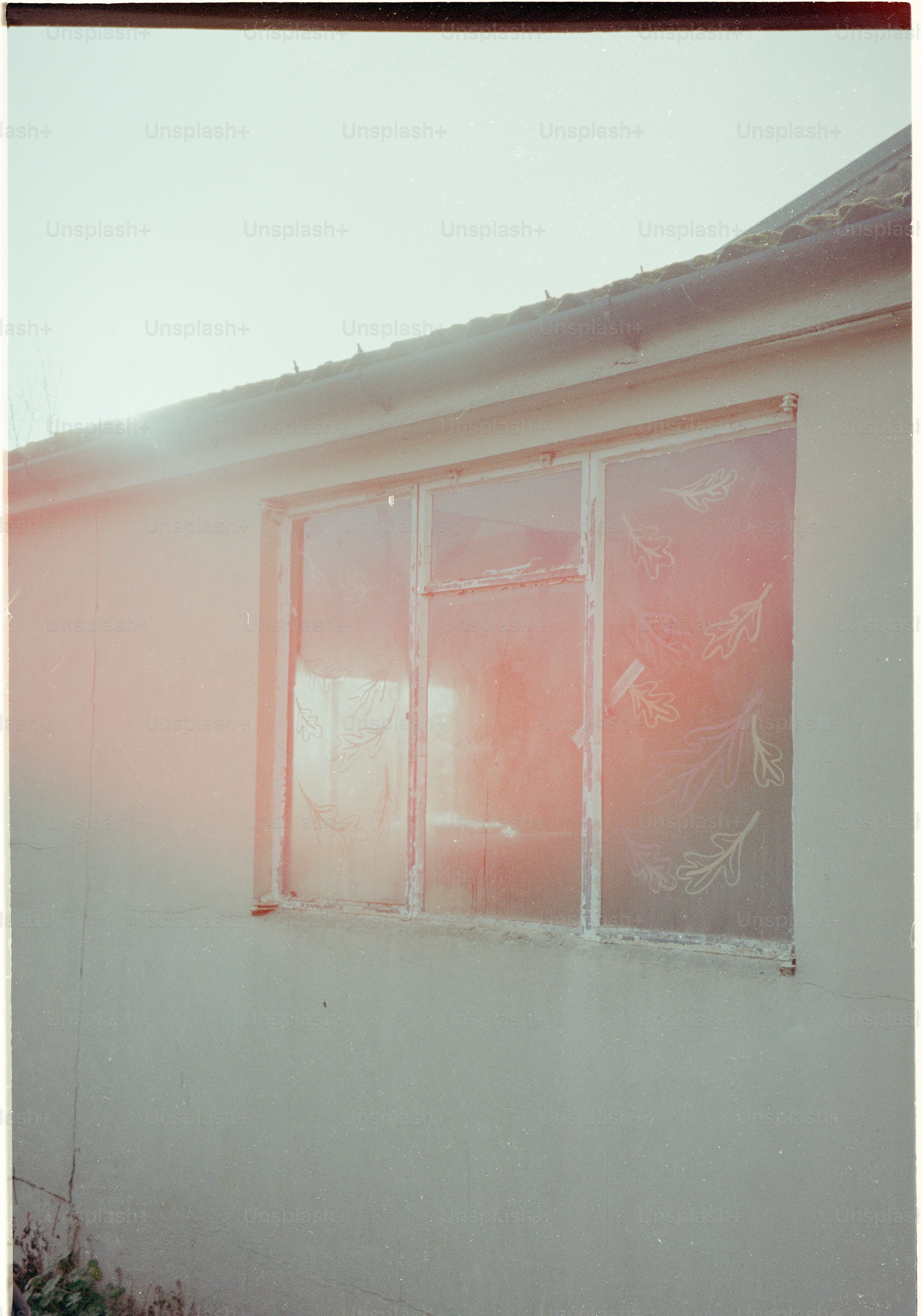 Sunlight reflects on a dusty window on a building.