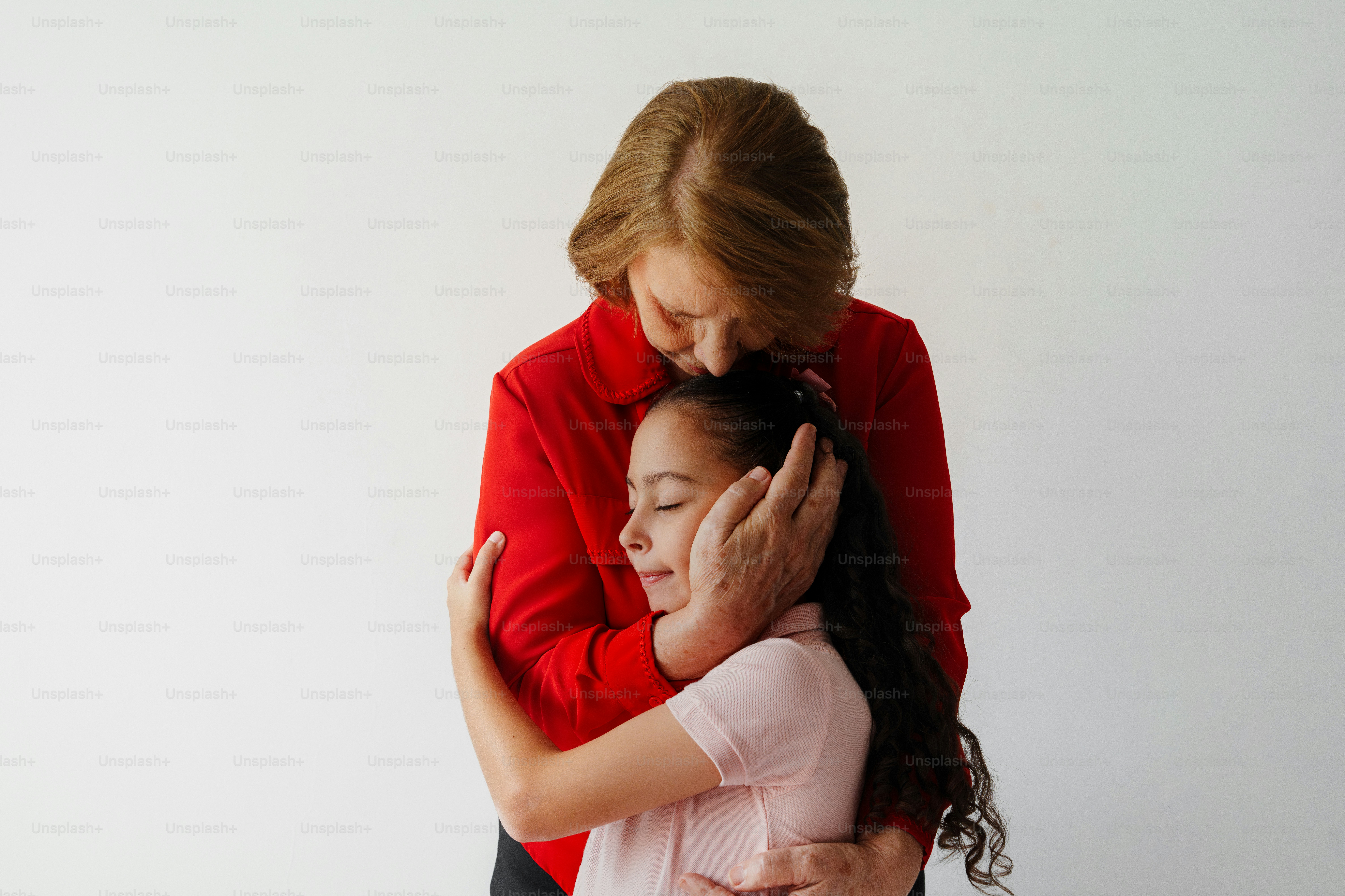 Woman hugging a young girl with eyes closed