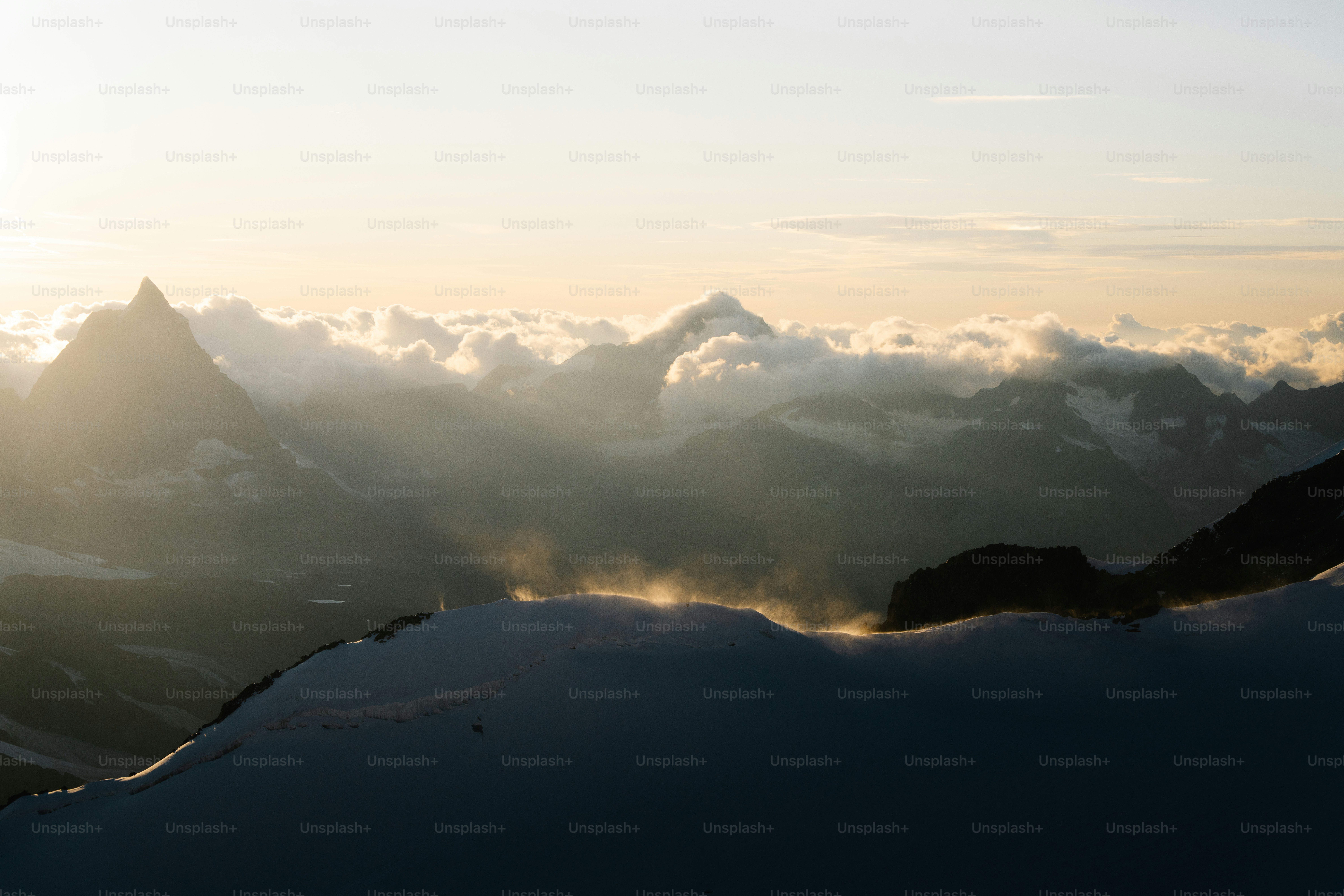La luce del sole che filtra tra le nuvole sopra le cime delle montagne