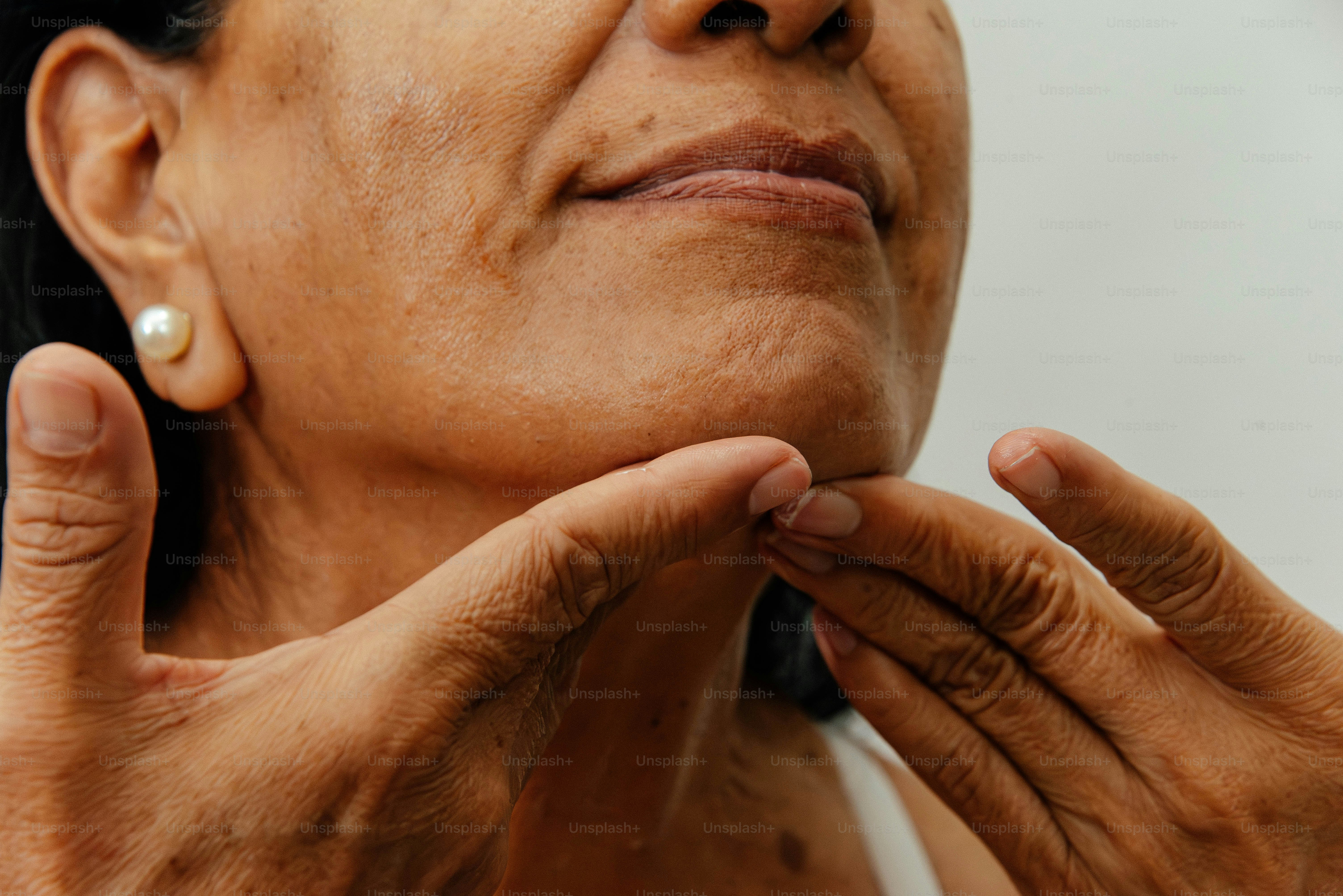 Frau berührt sanft ihr Kinn und ihren Hals