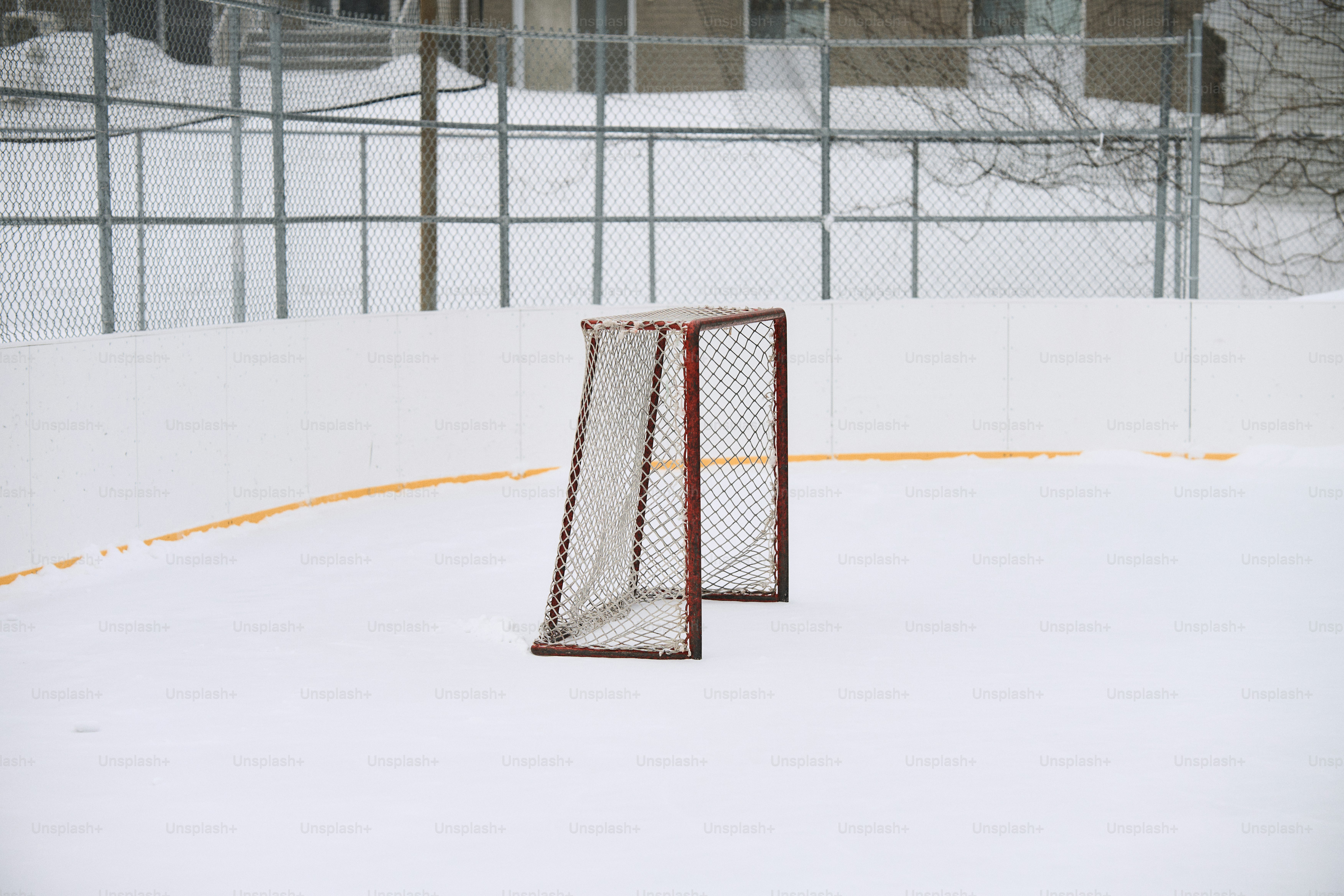 A snowy hockey rink with a goal net and net photo – Ice hockey Image on ...