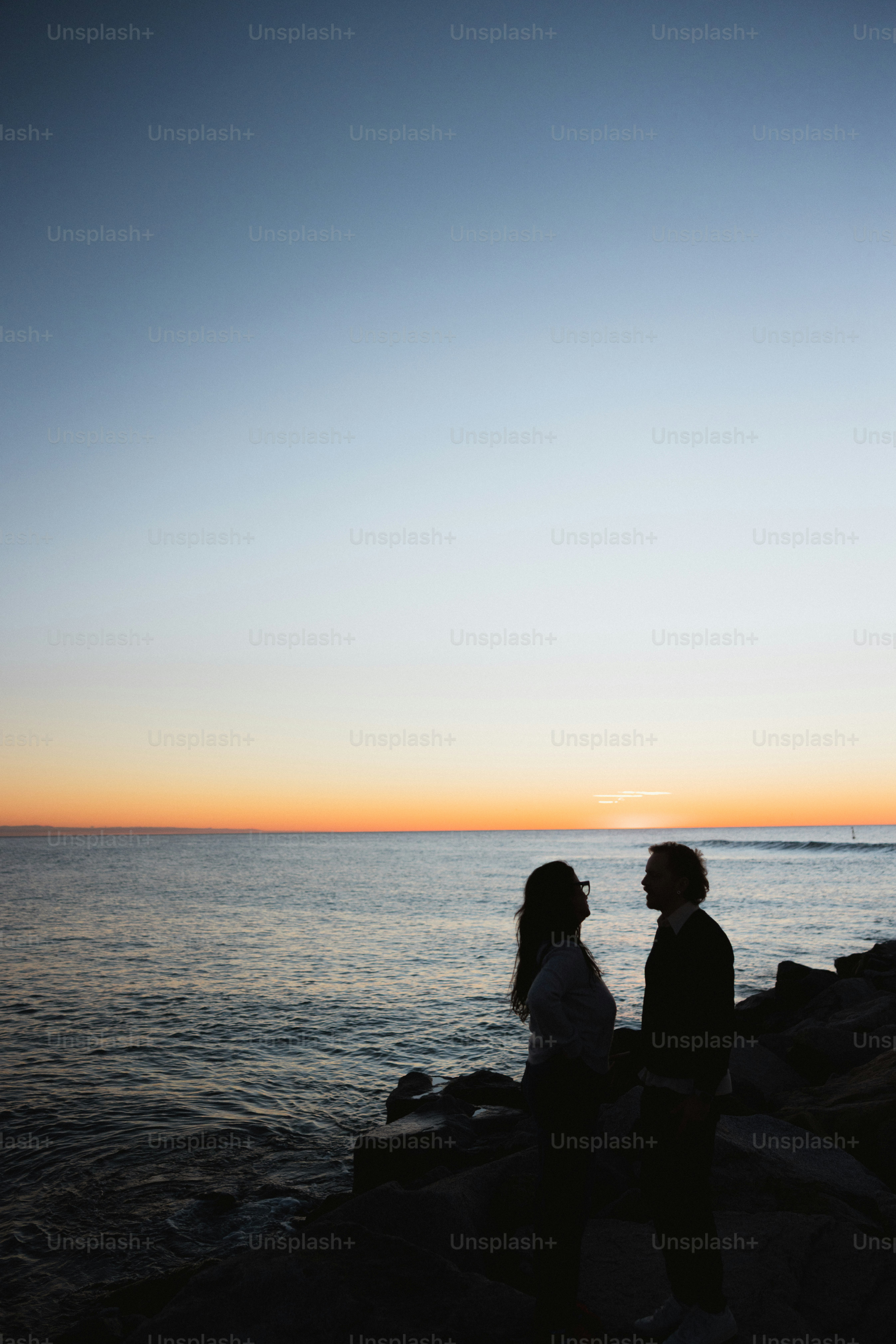 Couple silhouetté sur un coucher de soleil au bord de l’océan