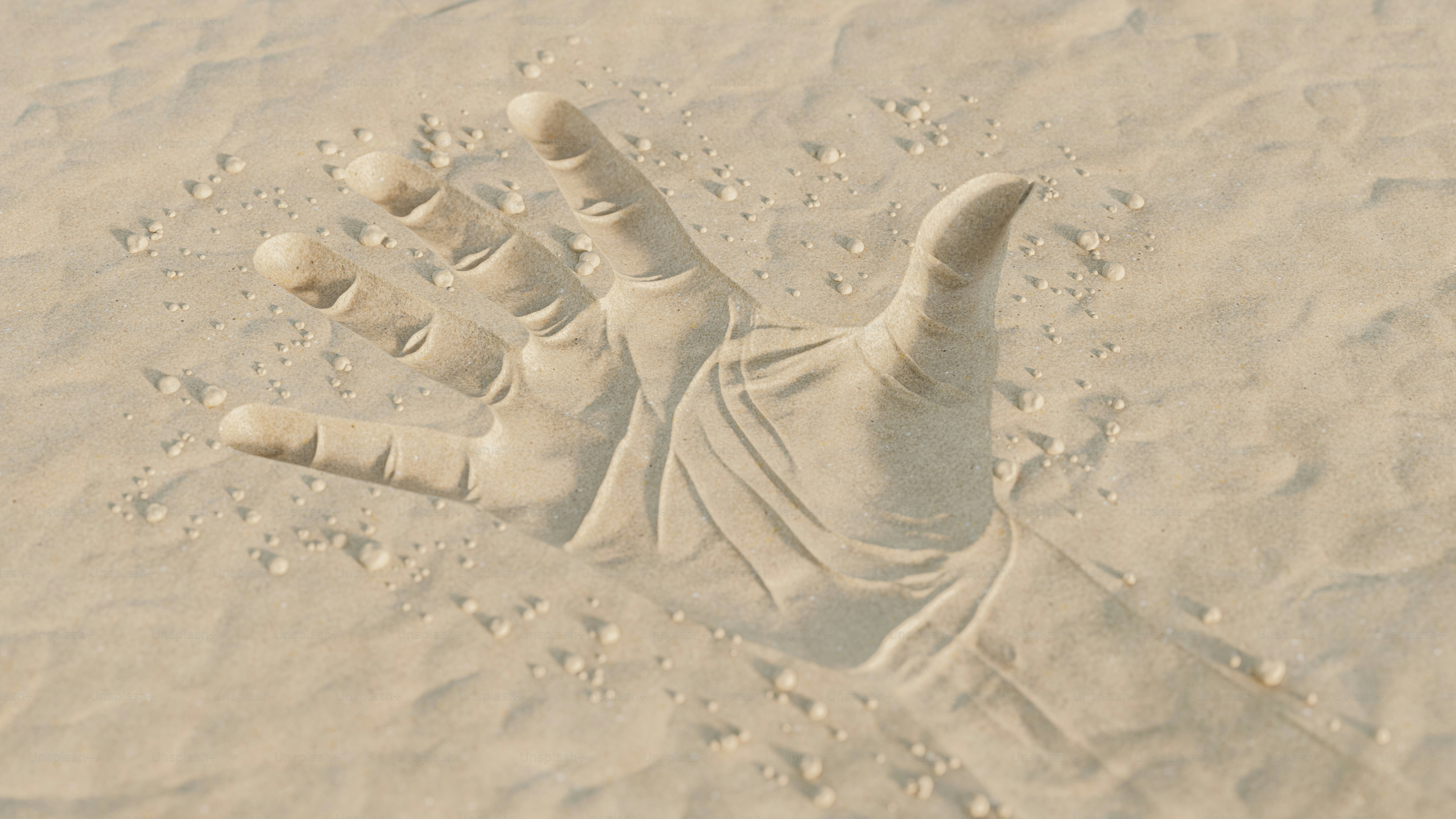 A hand emerging from dry sand