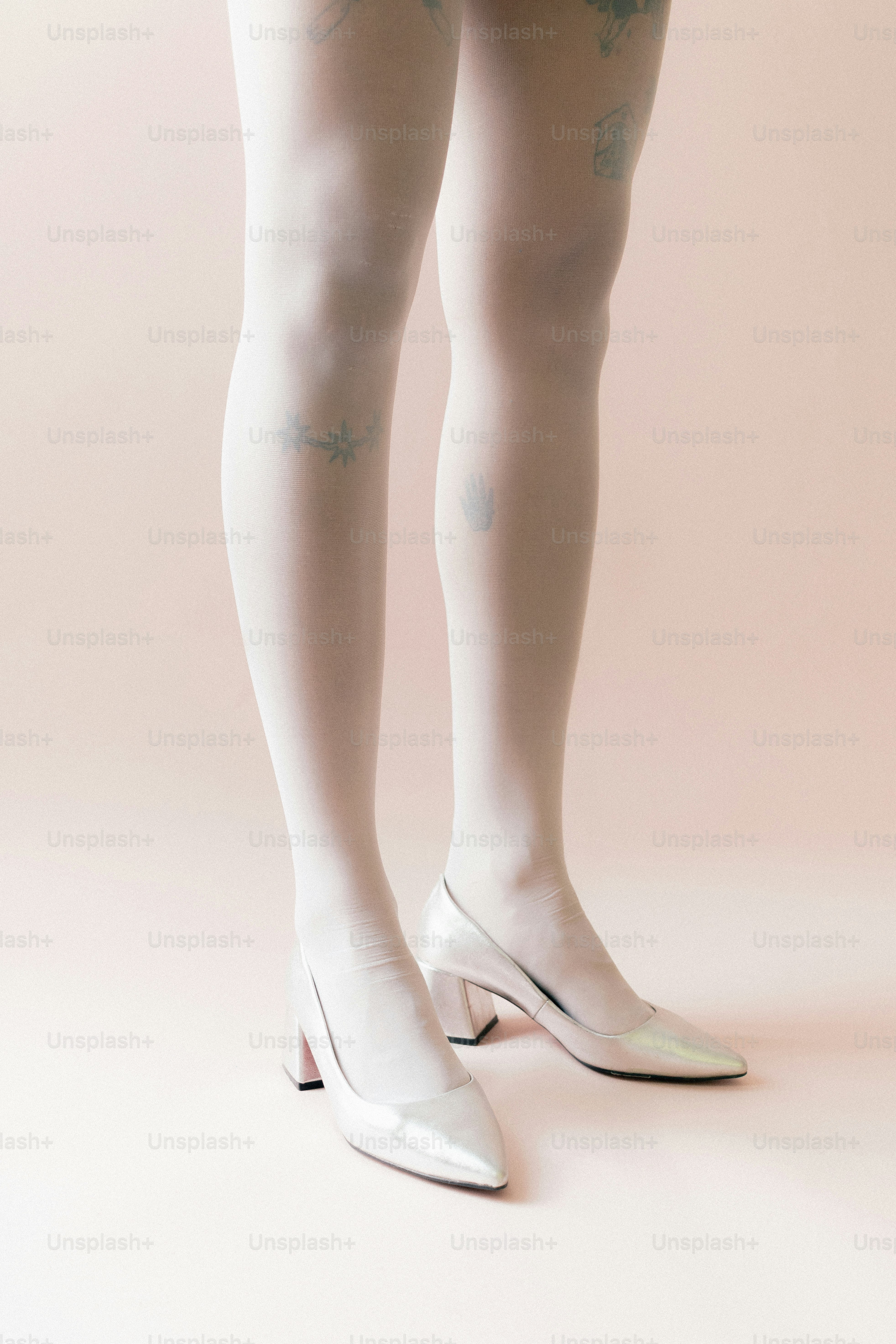 Femme portant des collants blancs et des talons argentés