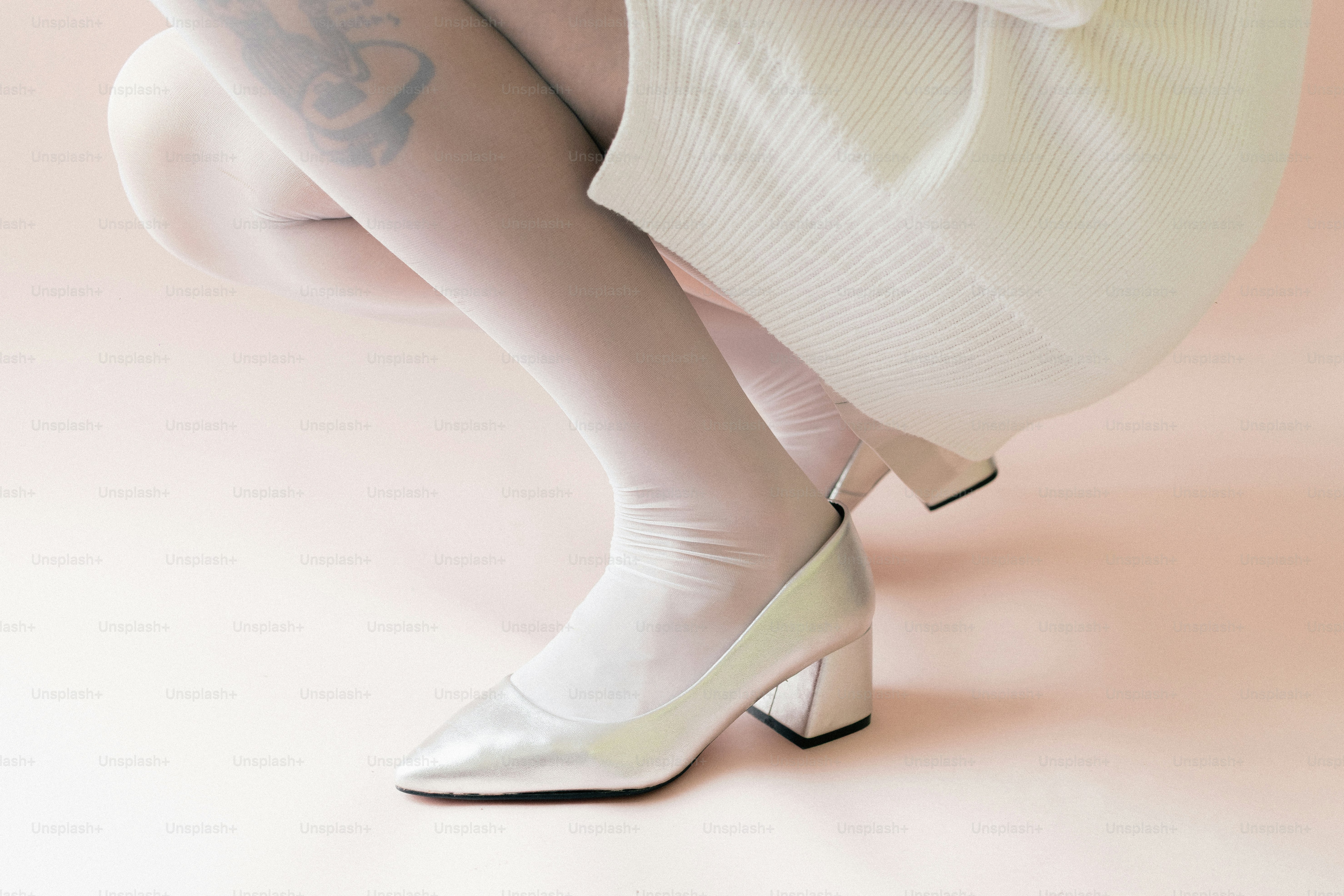 Frau mit silbernen High Heels und weißen Strumpfhosen